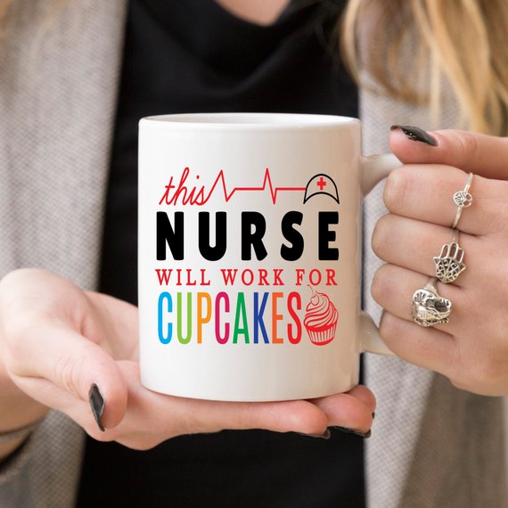 A high-quality ceramic coffee mug featuring the humorous text 'This Nurse Will Work For Cupcakes', perfect for nurses and coffee lovers.