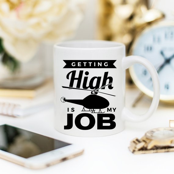 A humorous coffee mug with the phrase 'Getting High Is My Job' printed on it, showcasing a fun design perfect for coffee lovers.