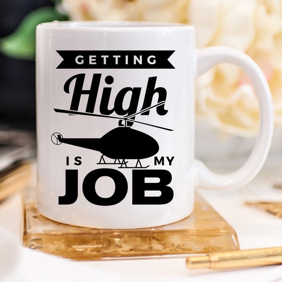 A humorous coffee mug with the phrase 'Getting High Is My Job' printed on it, showcasing a fun design perfect for coffee lovers.