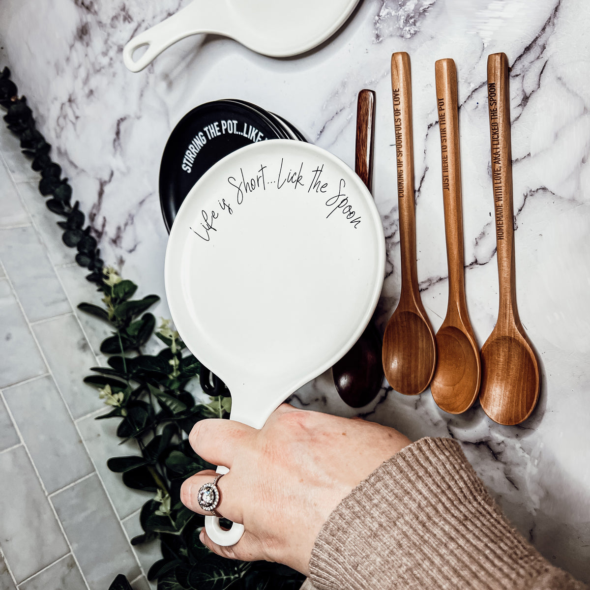 Give it a Rest LG spoon rest and wooden spoon set featuring various colors and fun quotes, perfect for keeping your kitchen clean.