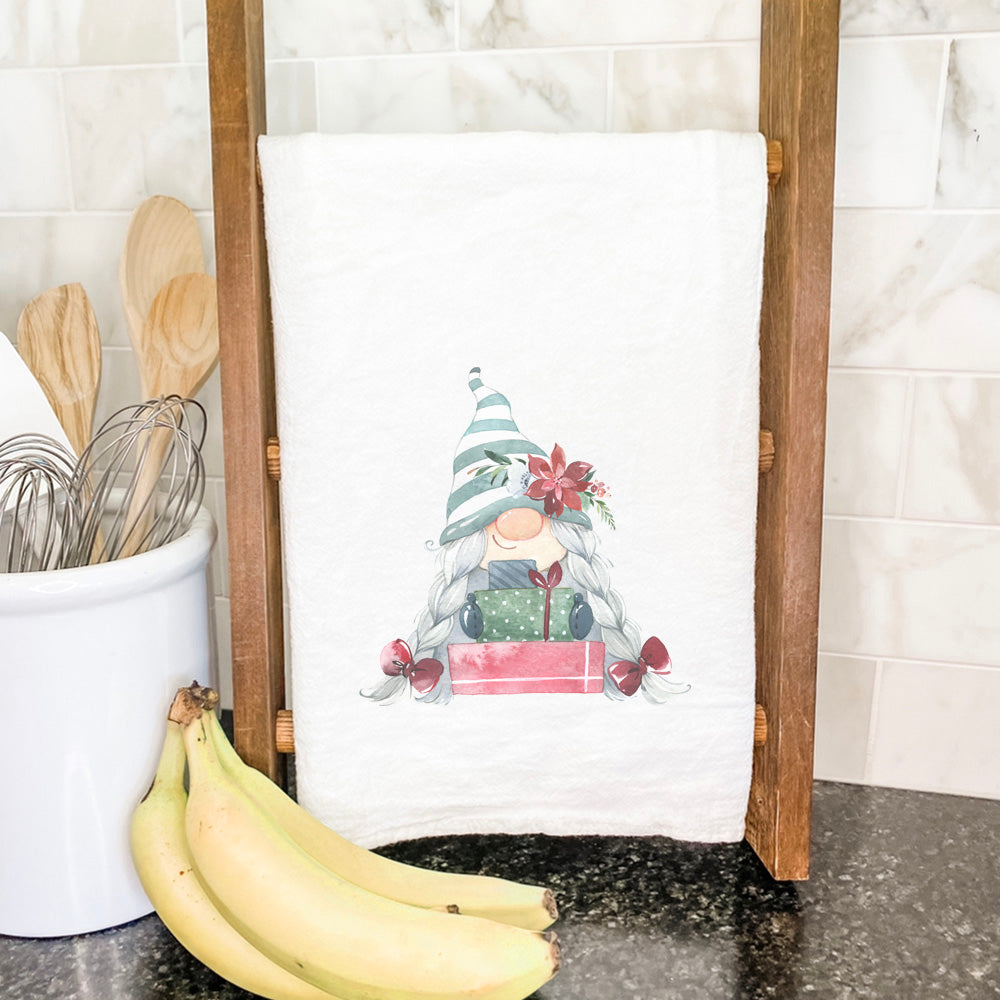 A colorful cotton tea towel featuring a whimsical gnome design with presents, perfect for kitchen use and holiday decor.