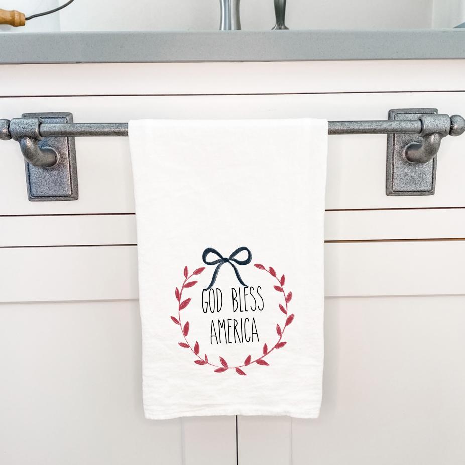 God Bless America Wreath cotton tea towel featuring vibrant colors and a patriotic design, perfect for kitchen use.