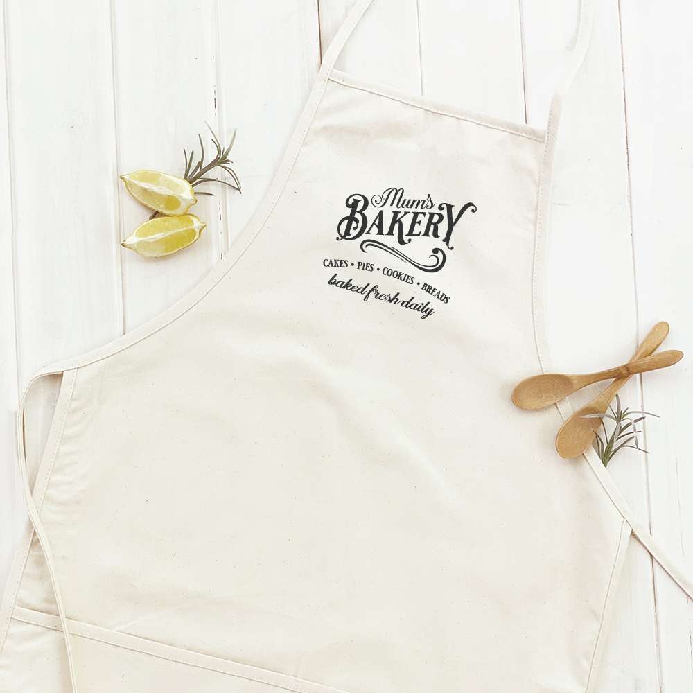 A stylish women's apron featuring a simple and elegant design, made from durable cotton canvas with natural twill ties and a divided front pocket.