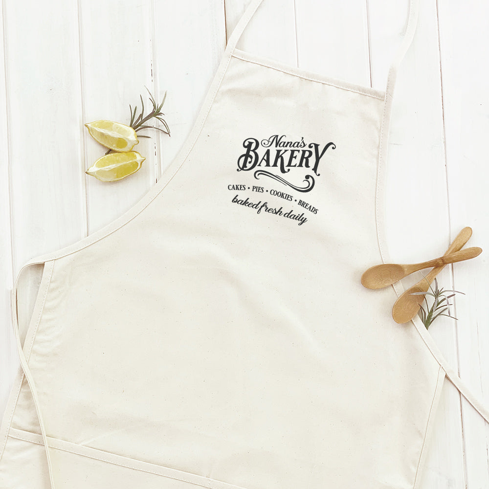 A stylish women's apron featuring a simple and elegant design, made from durable cotton canvas with natural twill ties and a divided front pocket.