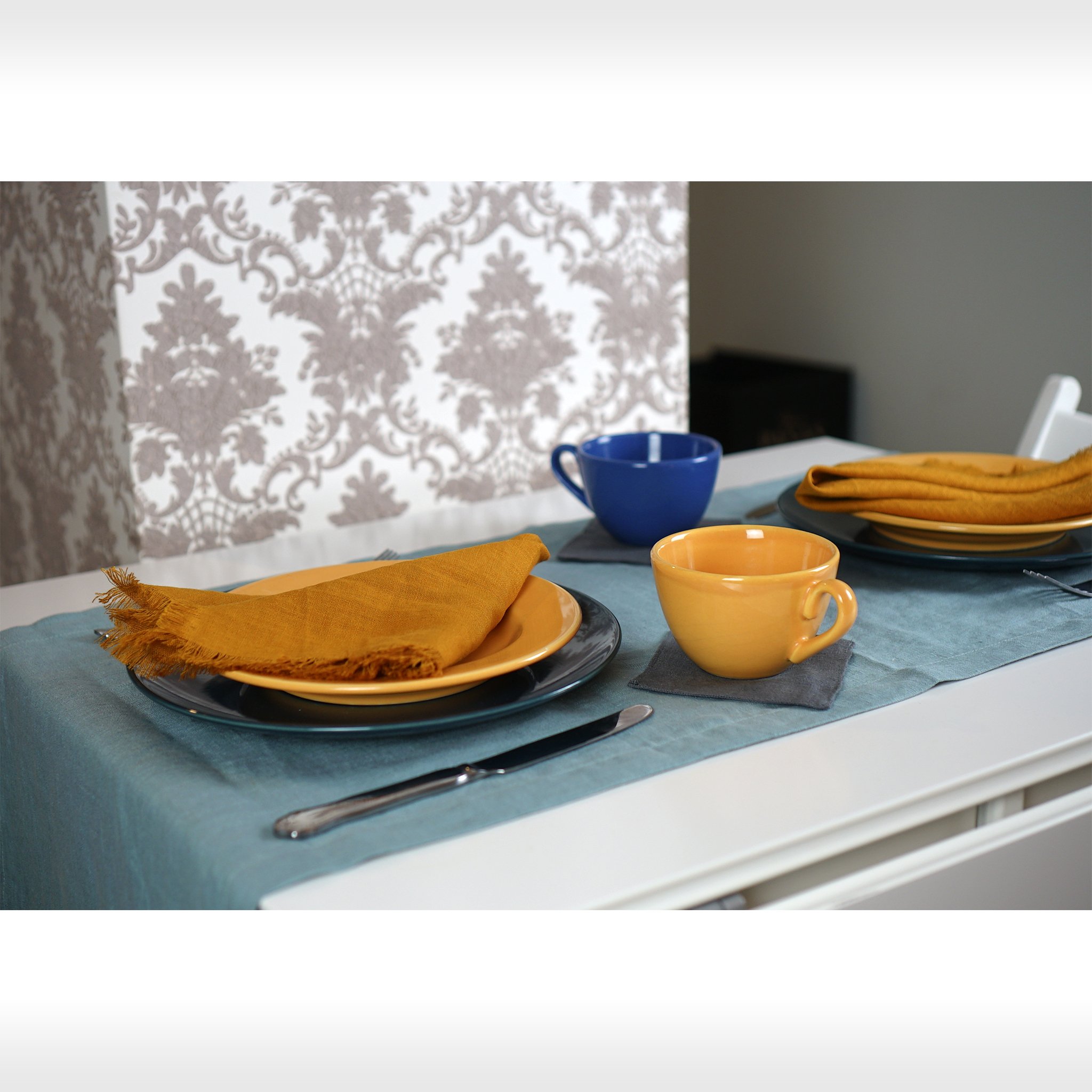 Greyish Mint linen table runner elegantly displayed on a dining table, showcasing its minimalist design and decorative hem.