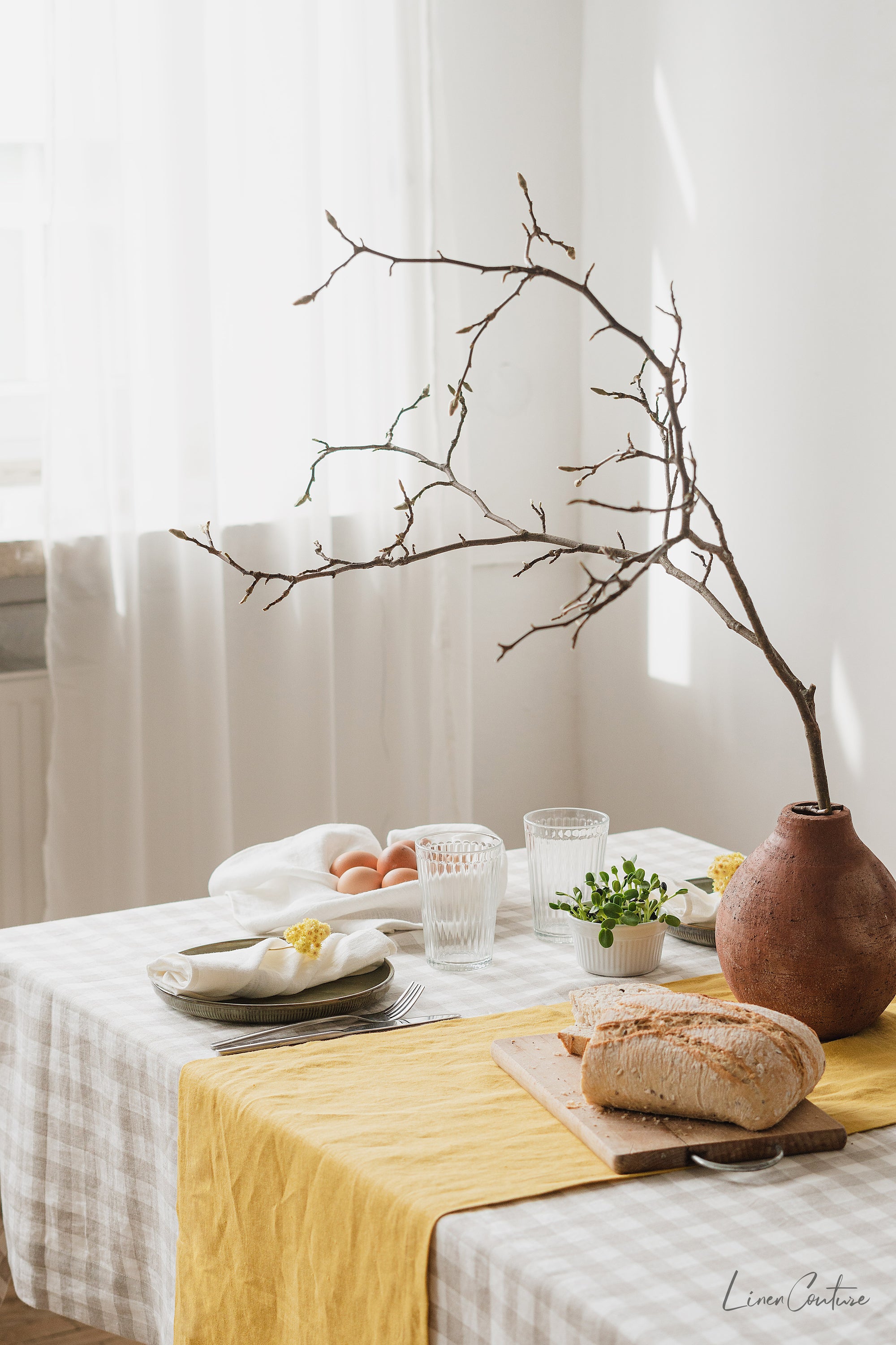 Greyish Mint linen table runner elegantly displayed on a dining table, showcasing its minimalist design and decorative hem.