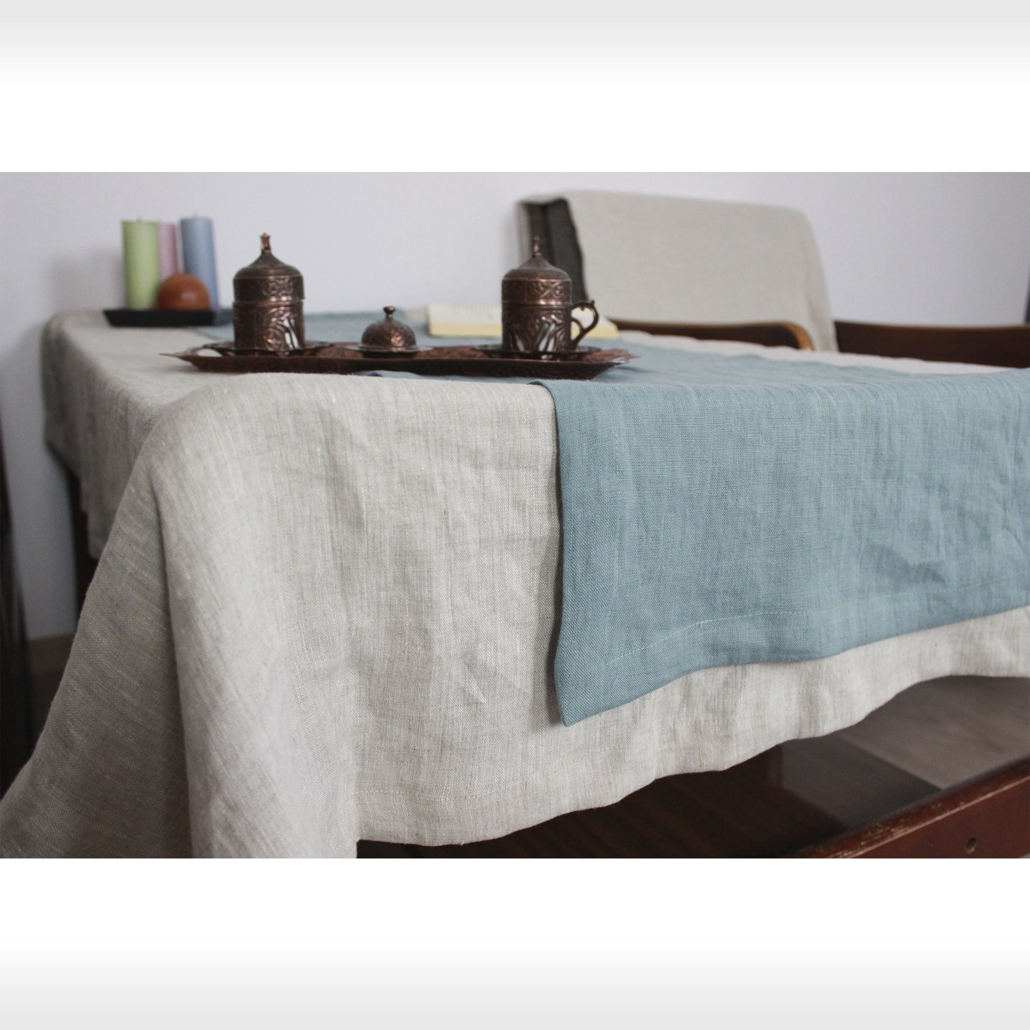 Greyish Mint linen table runner elegantly displayed on a dining table, showcasing its minimalist design and decorative hem.