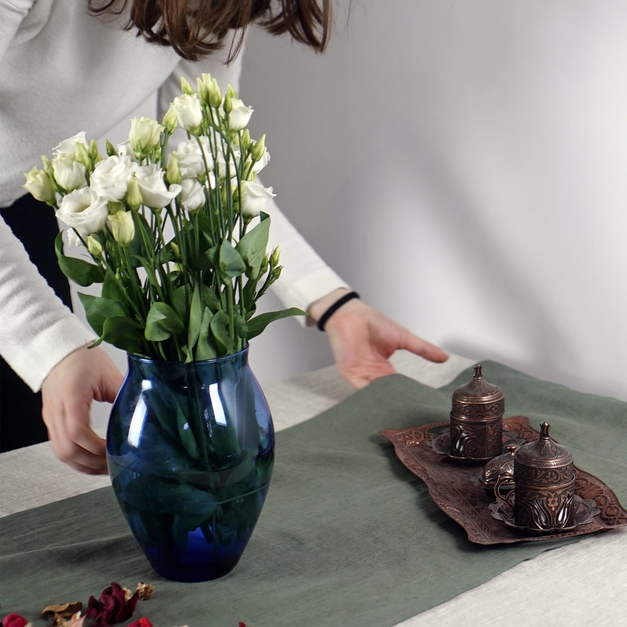 Greyish Mint linen table runner elegantly displayed on a dining table, showcasing its minimalist design and decorative hem.