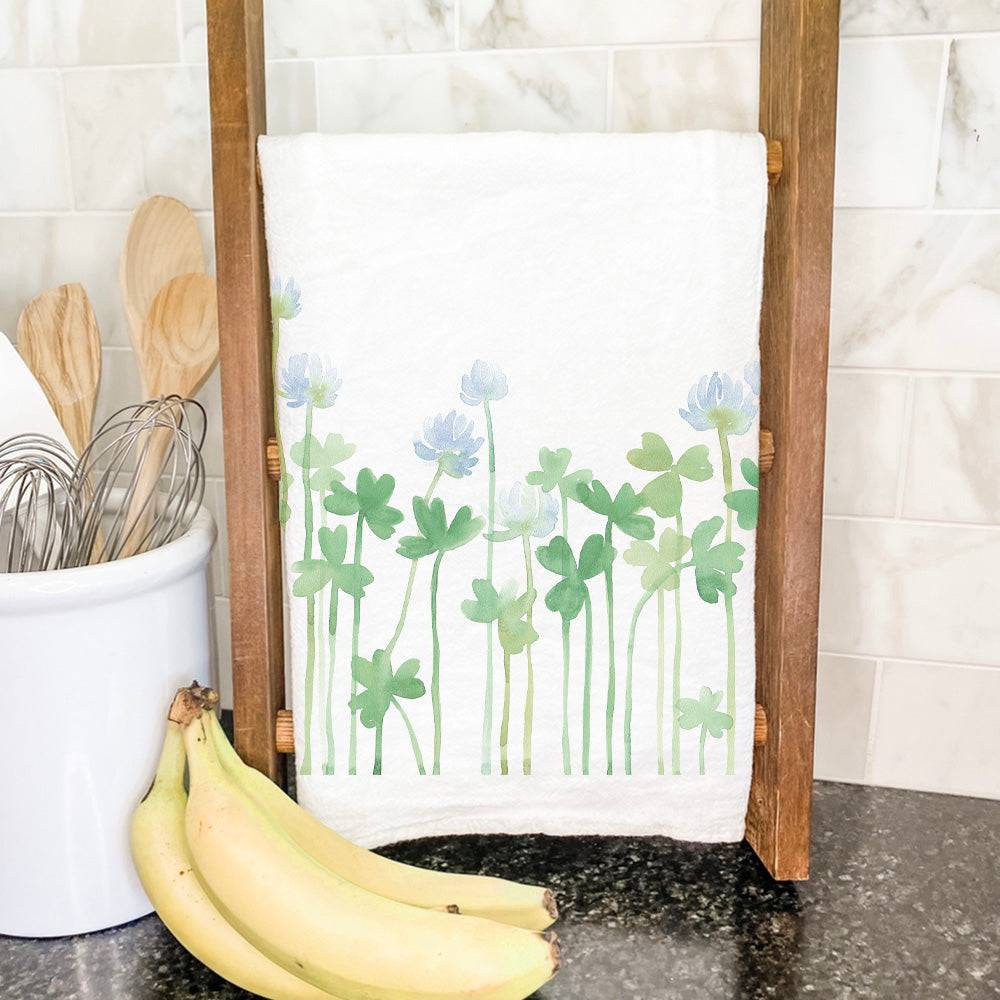 A vibrant cotton tea towel featuring a beautiful Growing Clover design, perfect for kitchen use.