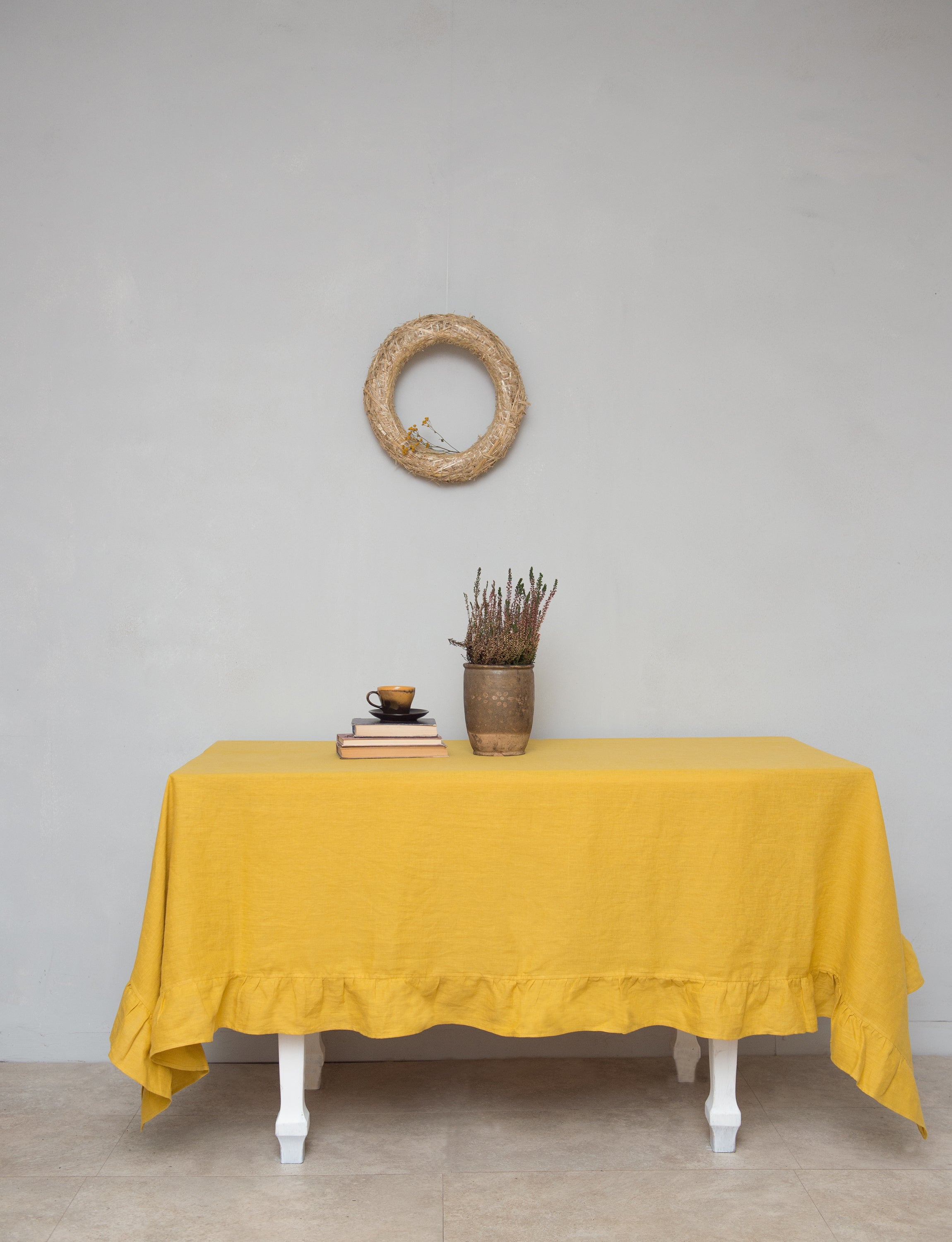 Bright honey-colored linen tablecloth with elegant ruffles, showcasing its luxurious texture and drape.