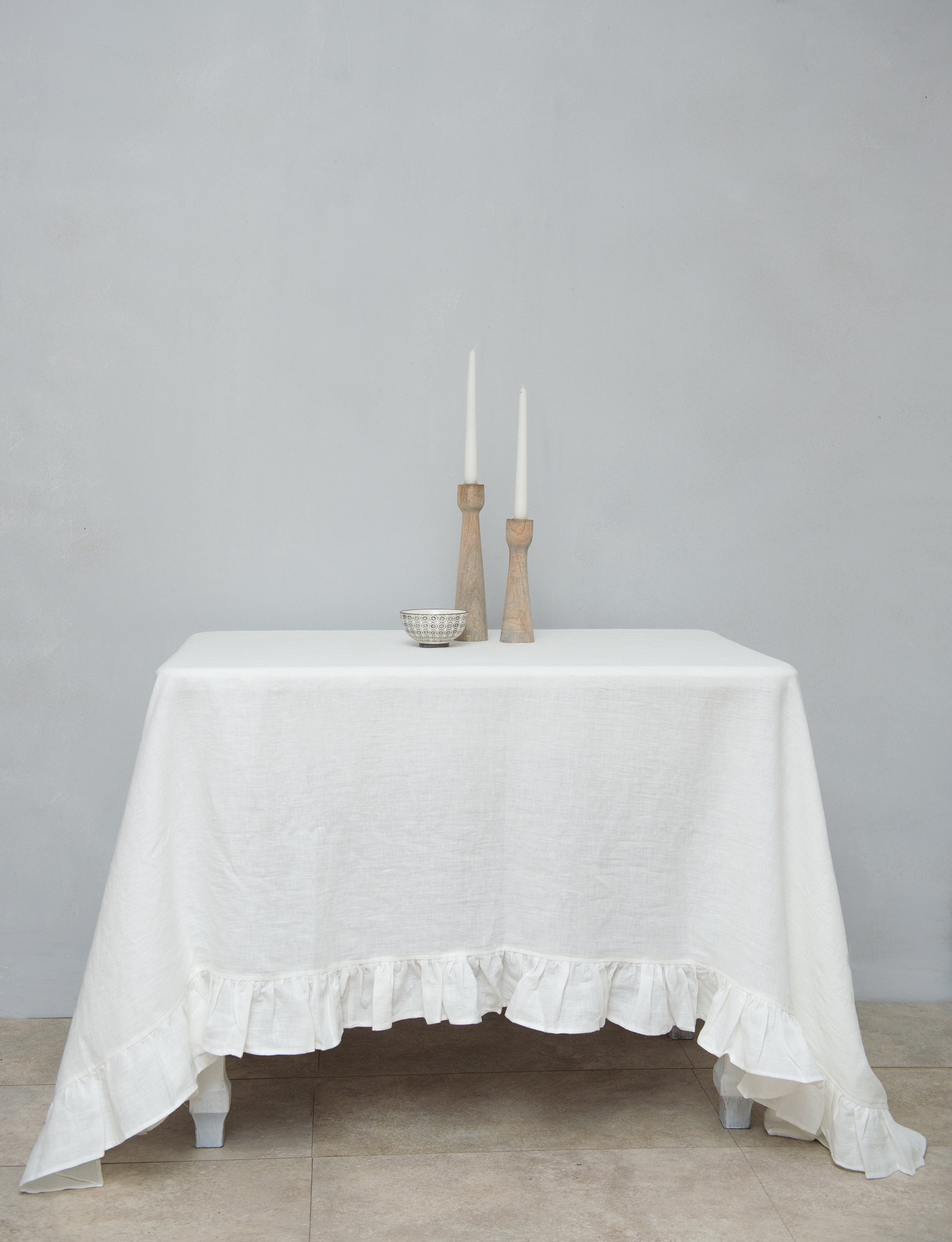 Bright honey-colored linen tablecloth with elegant ruffles, showcasing its luxurious texture and drape.