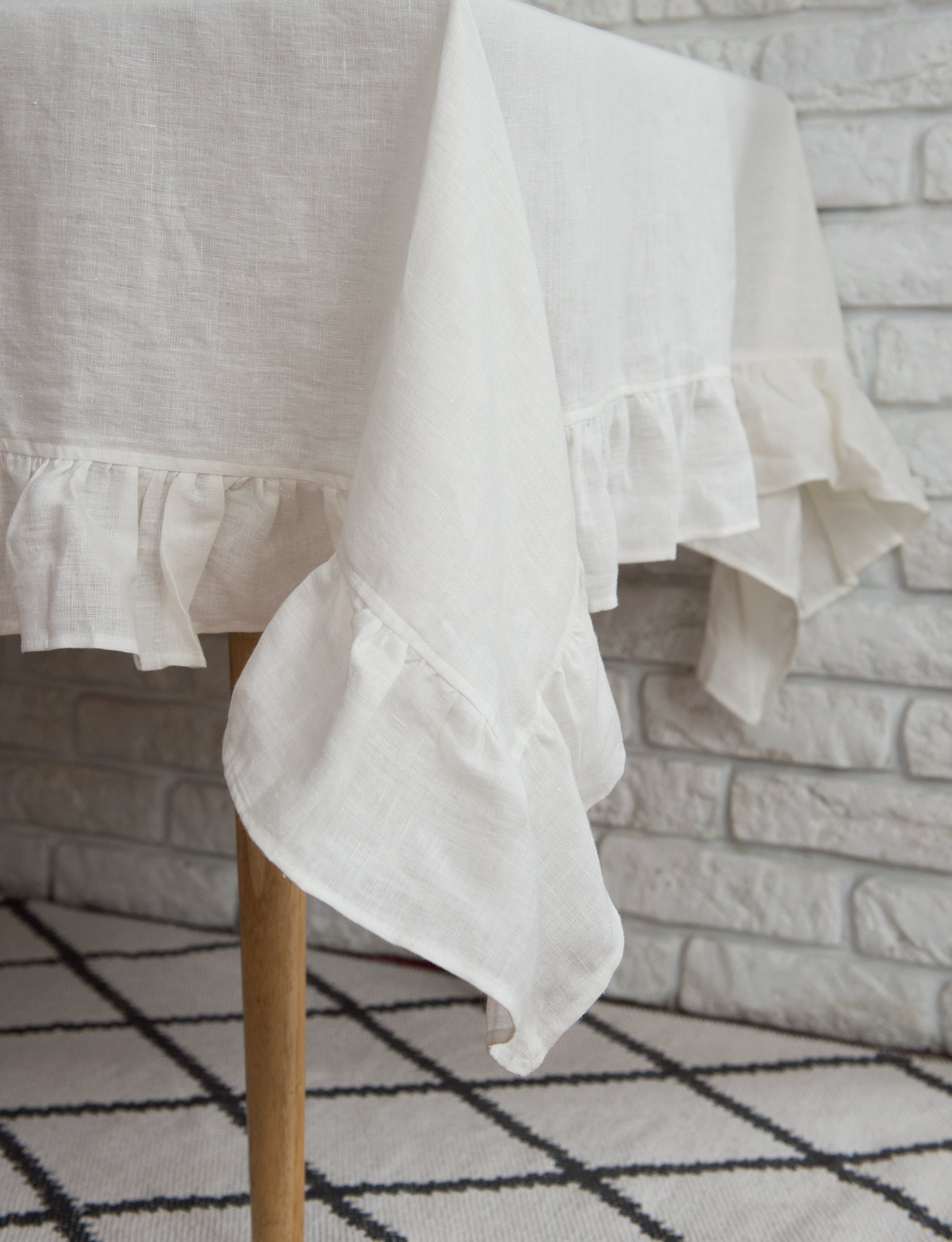 Bright honey-colored linen tablecloth with elegant ruffles, showcasing its luxurious texture and drape.