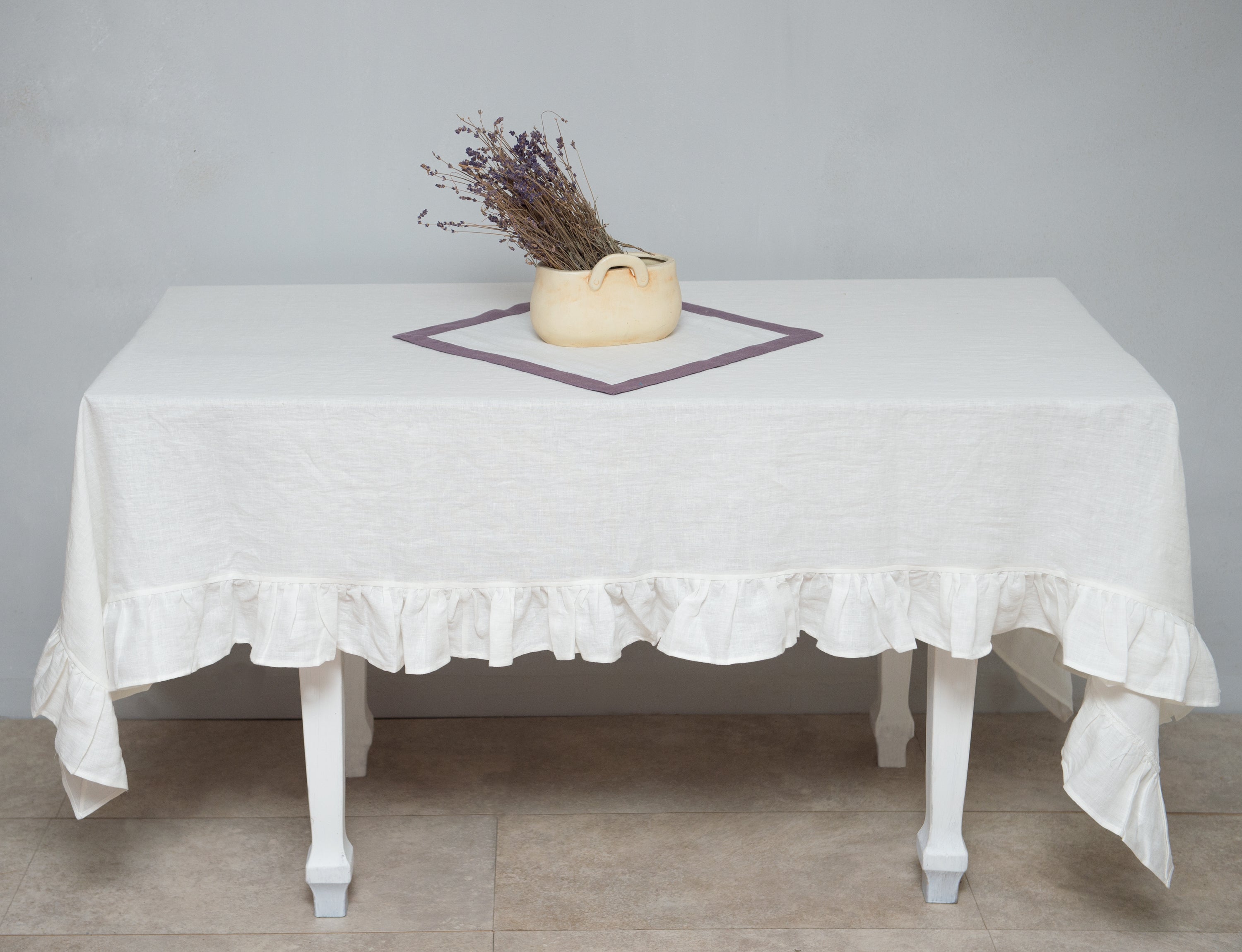 Bright honey-colored linen tablecloth with elegant ruffles, showcasing its luxurious texture and drape.