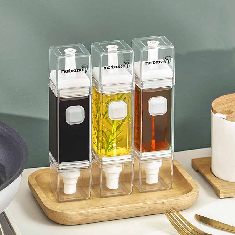 A transparent leak-proof oil bottle made from Tritan, designed for kitchen use, showcasing its compact size and sleek design.