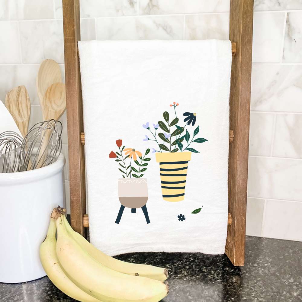 A vibrant cotton tea towel featuring a beautiful houseplant design, perfect for kitchen use.