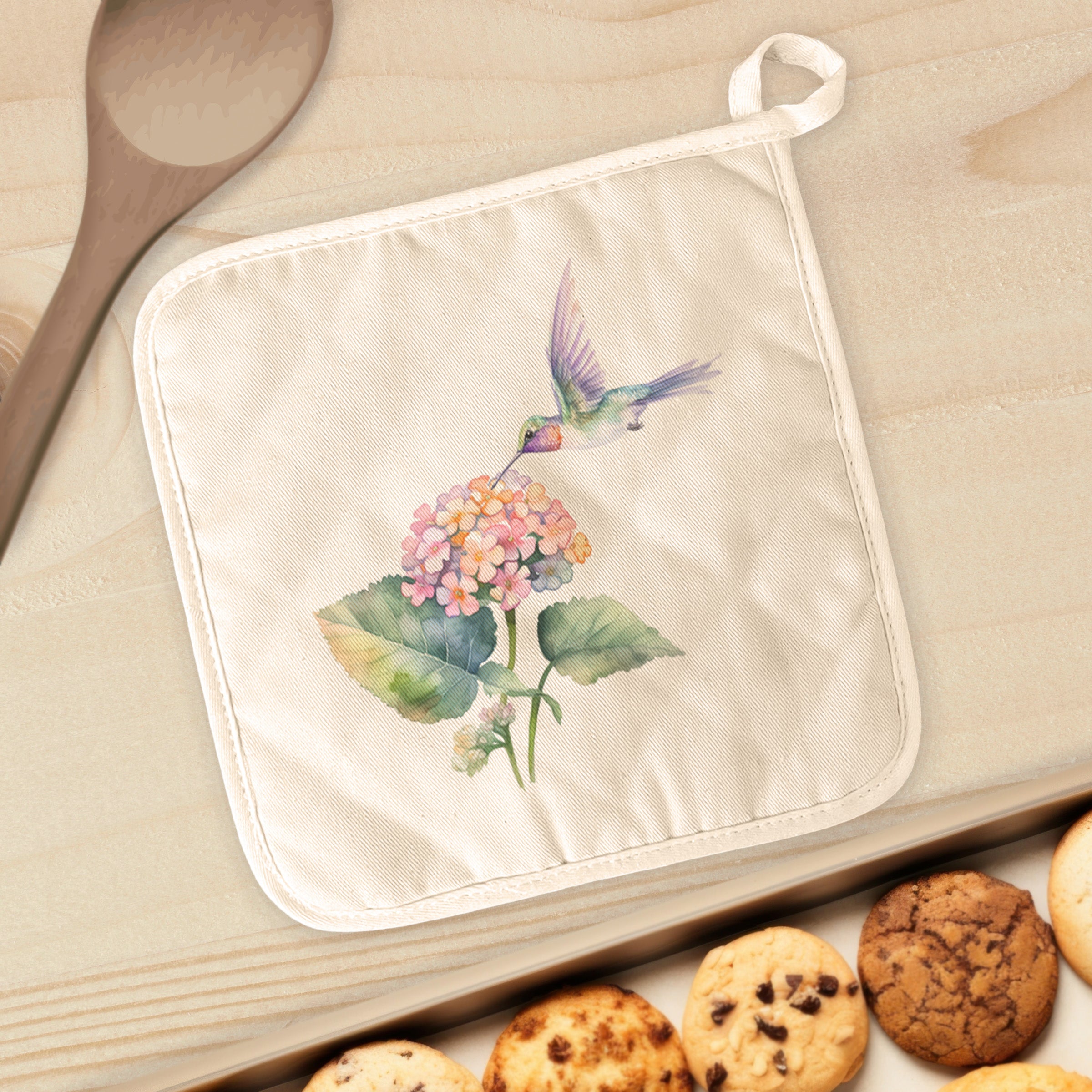 A vibrant cotton pot holder featuring a Hummingbird and Lantana Flower design, perfect for protecting surfaces from hot cookware.