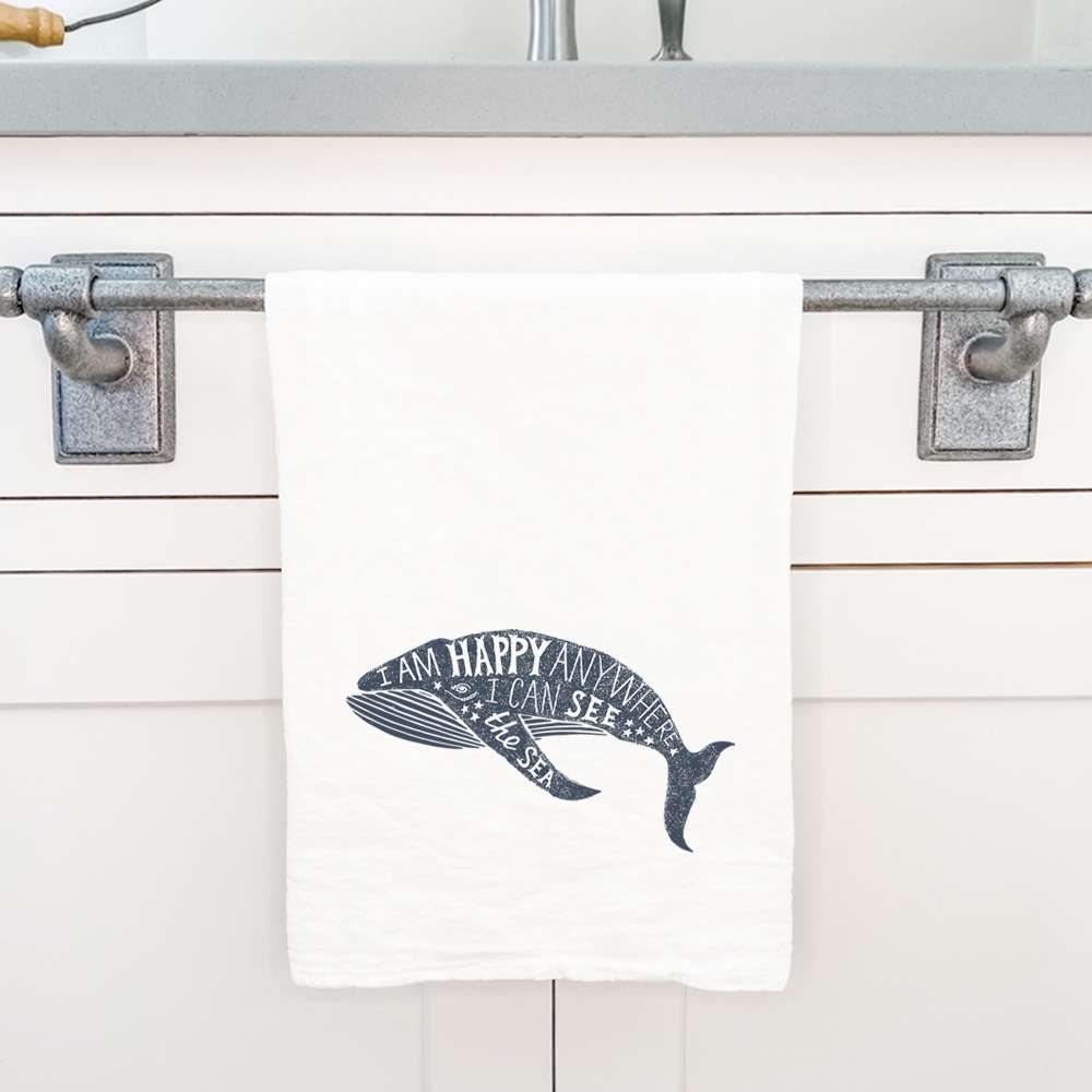 I am Happy Anywhere cotton tea towel featuring a whimsical whale design, made from 100% absorbent cotton.