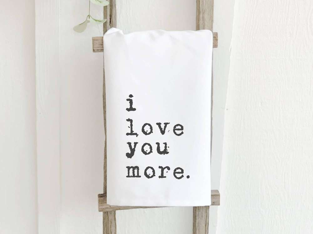 I Love You More Cotton Tea Towel featuring vibrant design and hemmed edges, perfect for kitchen use.