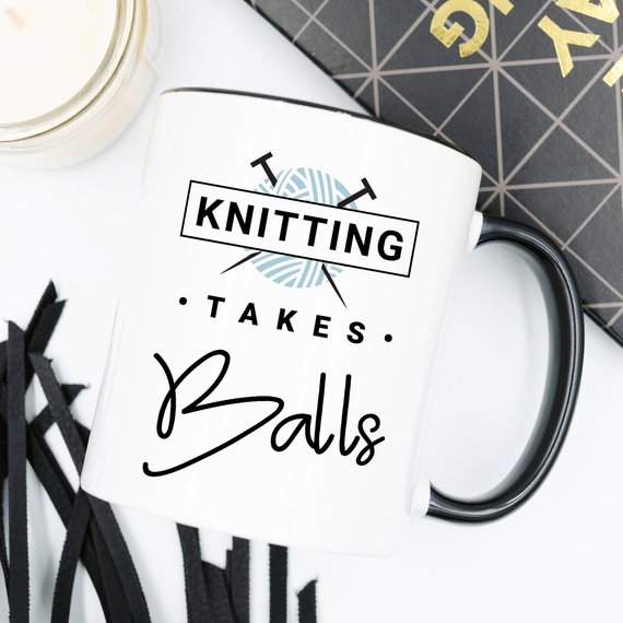 A humorous coffee mug with the phrase 'Knitting Takes Balls', featuring a colorful design perfect for knitting enthusiasts.