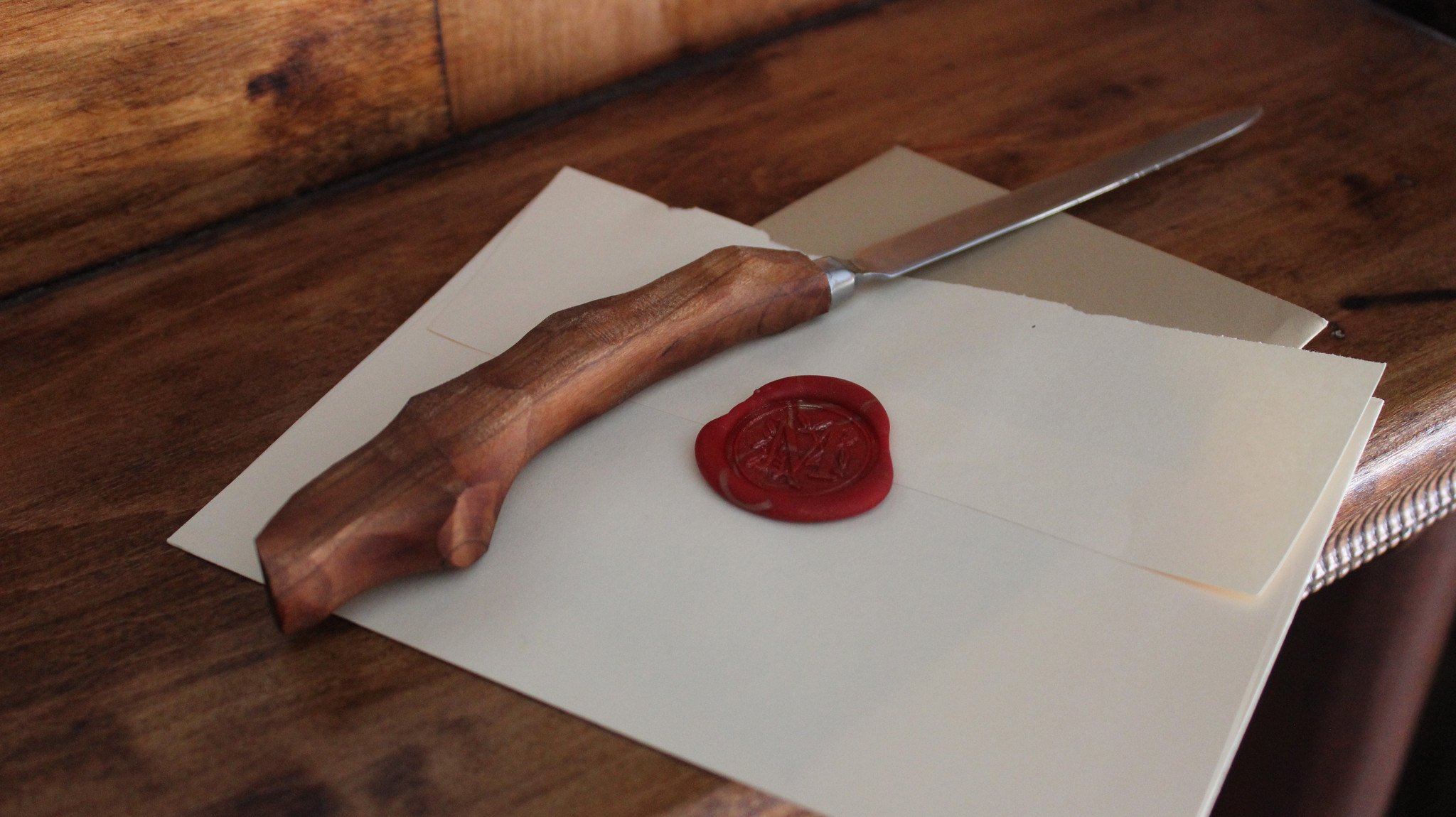 Elegant letter opener with a chiseled design, featuring a smooth handle and pinky hook, available in various wood types.