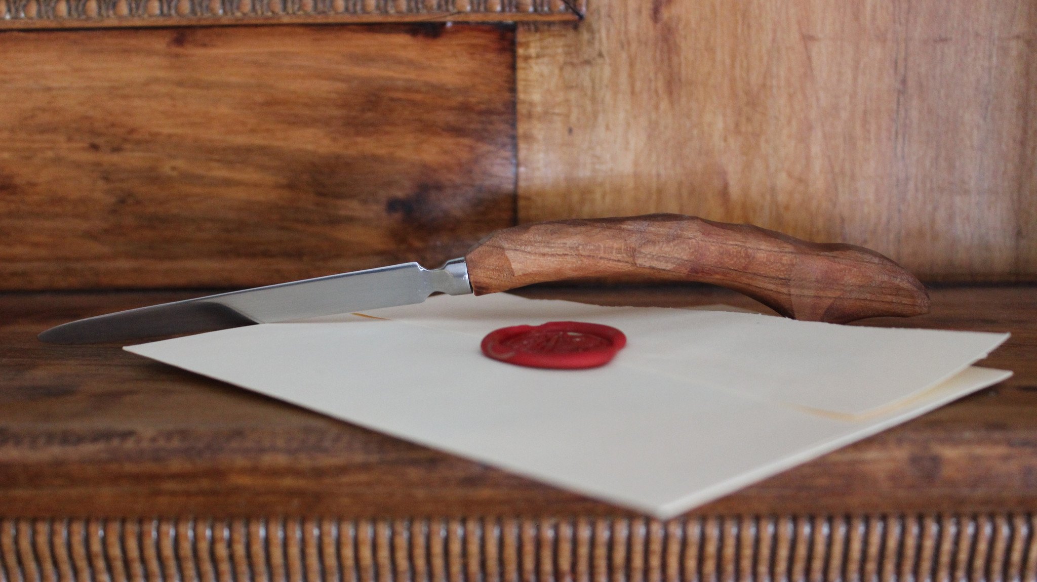 Elegant letter opener with a chiseled design, featuring a smooth handle and pinky hook, available in various wood types.