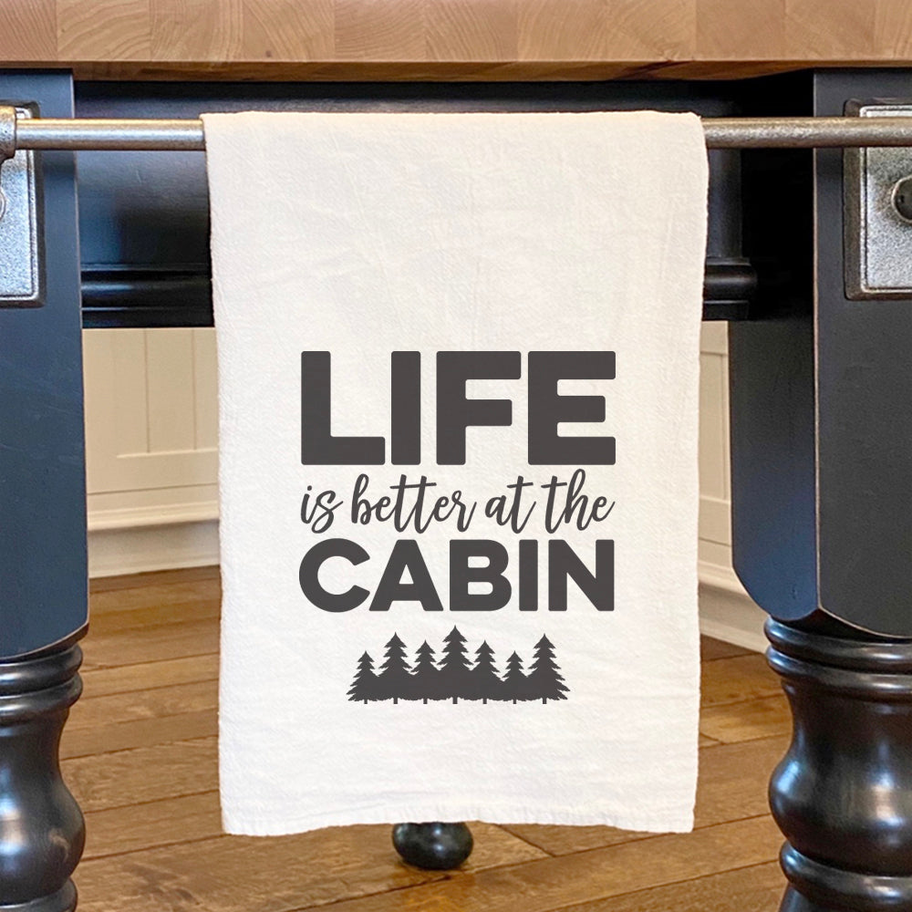 Cotton tea towel featuring a vibrant tree design with the phrase 'Life is Better at the Cabin', perfect for kitchen use.