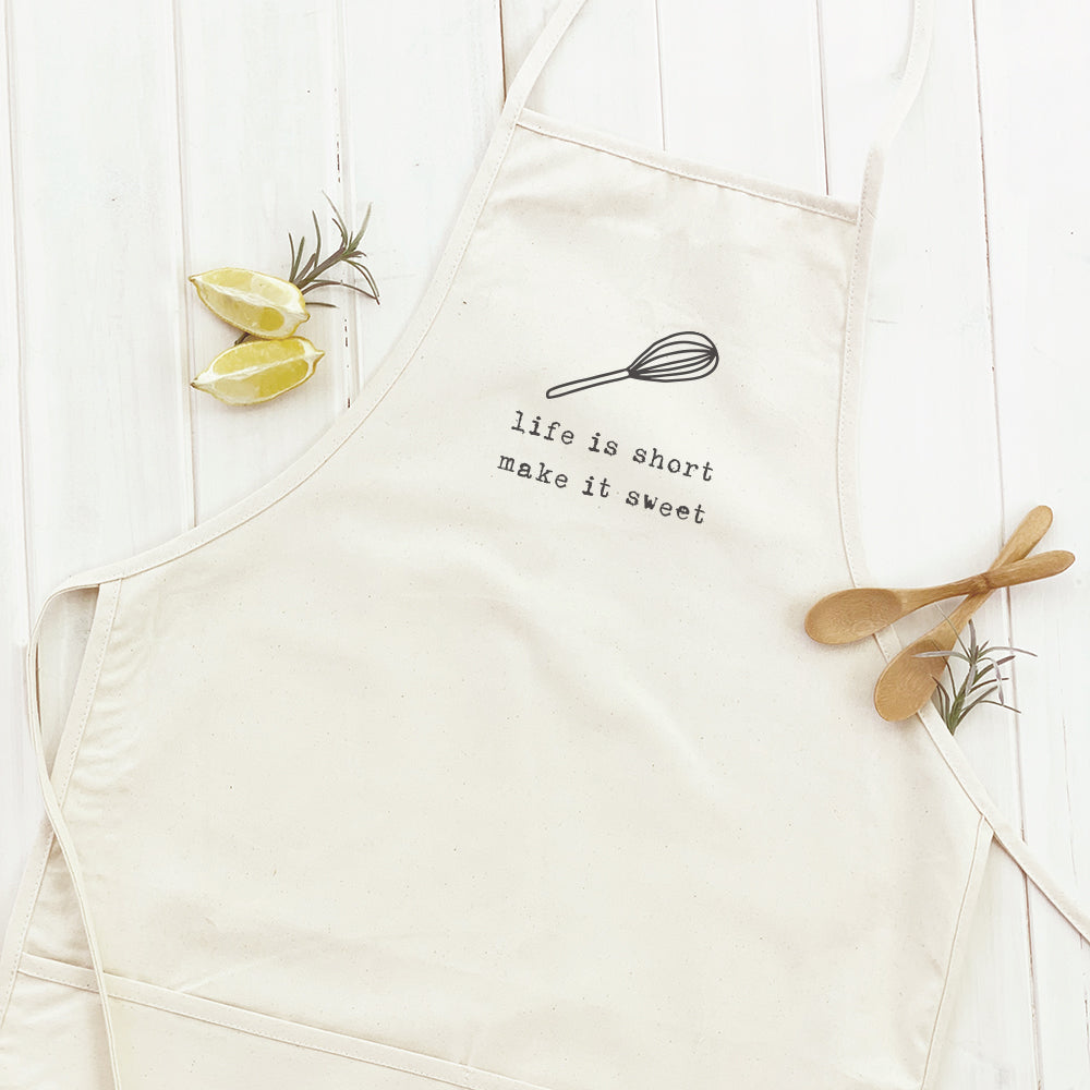 Life is Short (Whisk) Women's Apron in cotton canvas with natural twill ties and a divided front pocket, featuring a stylish design.