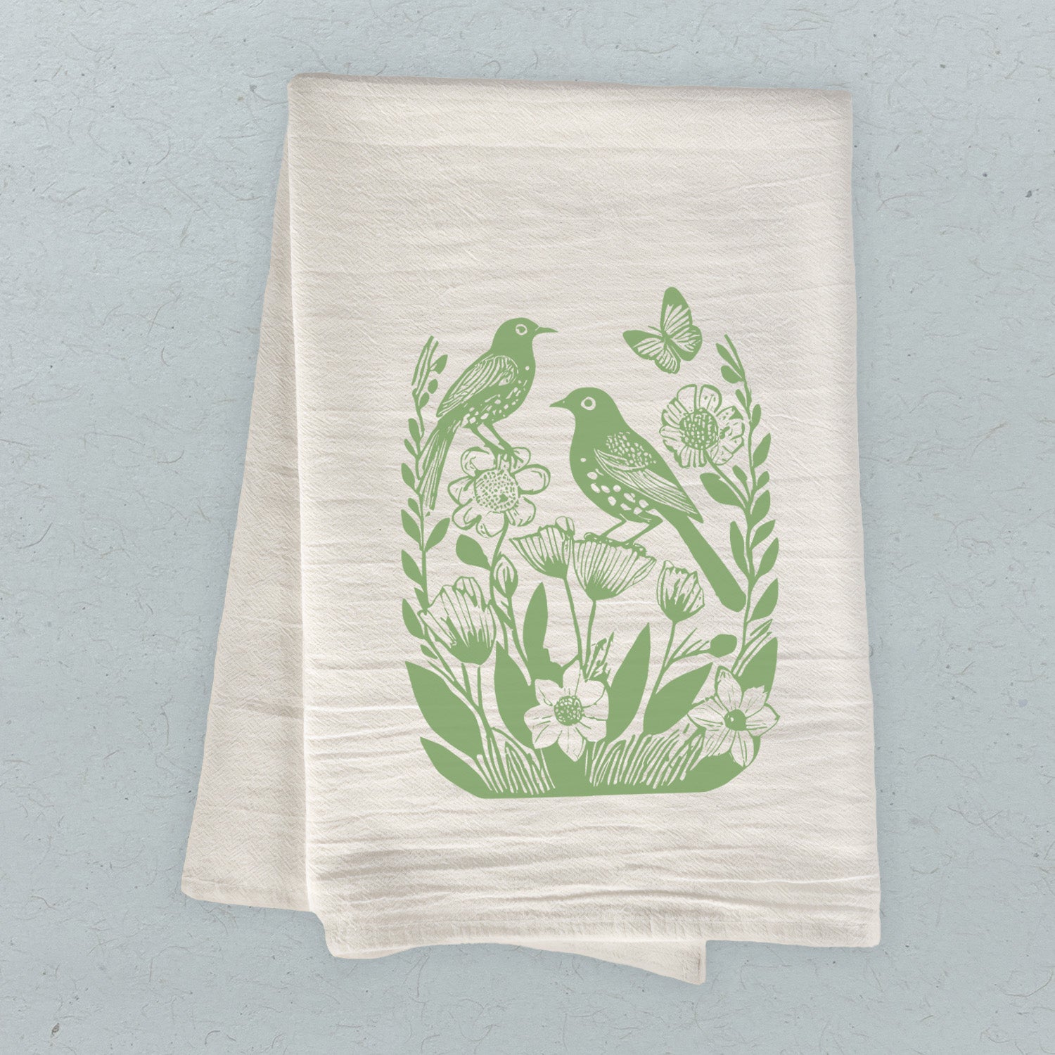 A vibrant cotton tea towel featuring a linocut design of spring birds, perfect for kitchen use.