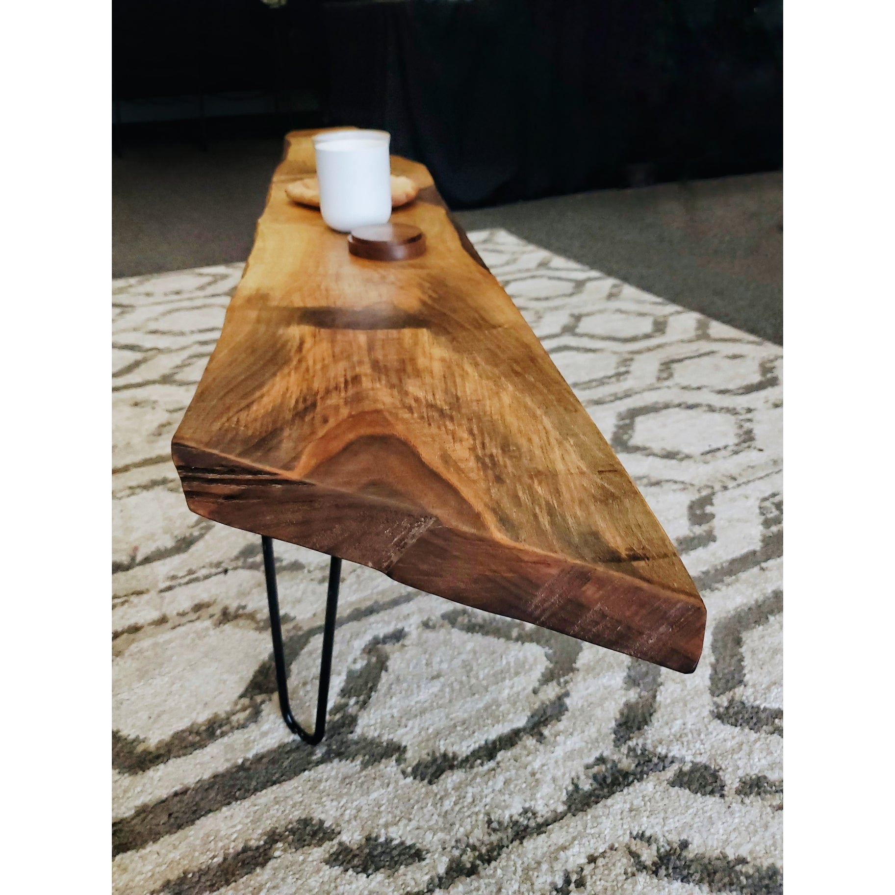 Live edge coffee table featuring walnut or cherry wood with black metal hairpin legs, showcasing unique wood grain and natural imperfections.