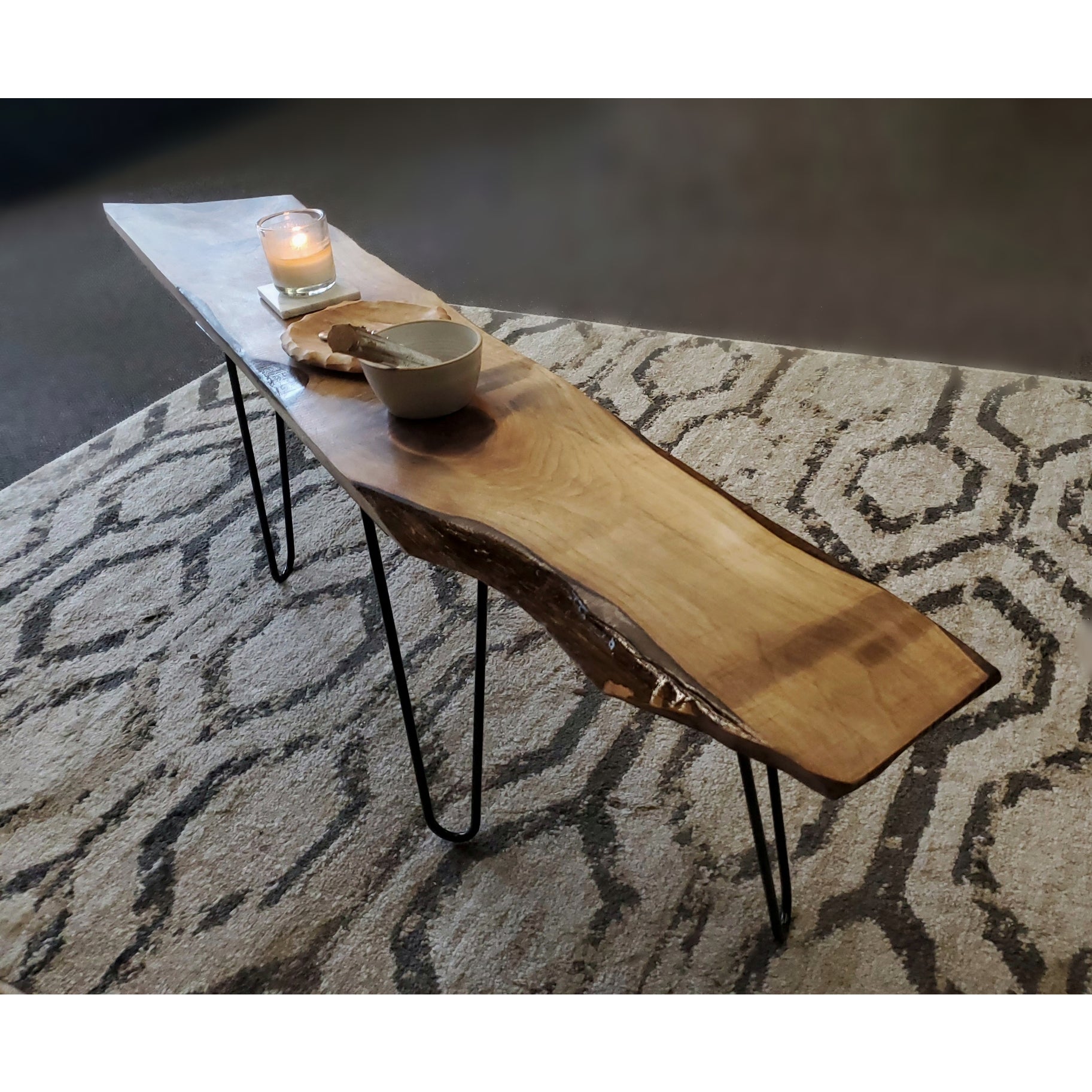 Live edge coffee table featuring walnut or cherry wood with black metal hairpin legs, showcasing unique wood grain and natural imperfections.