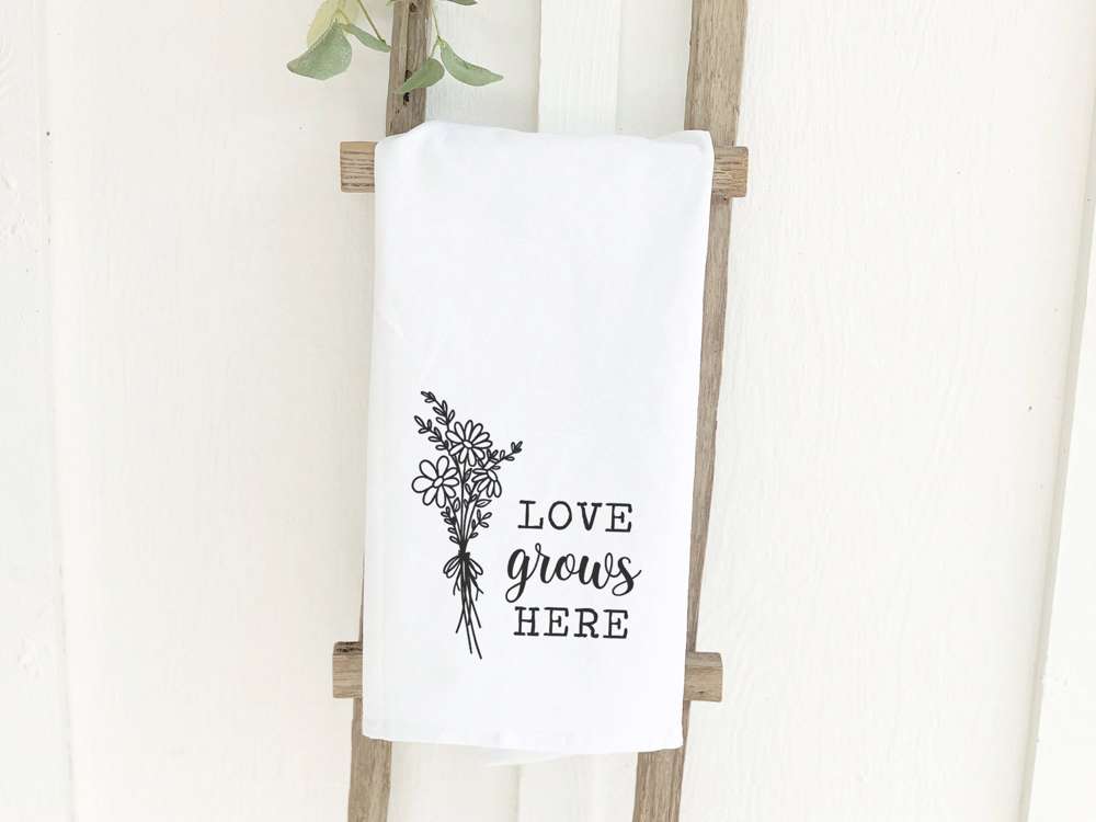 Love Grows Here Bouquet cotton tea towel featuring vibrant floral design, perfect for kitchen use.