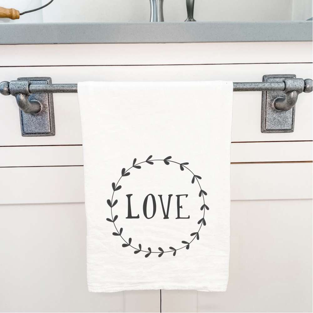 Love Simple Wreath Cotton Tea Towel featuring a vibrant wreath design, made from 100% absorbent cotton, perfect for kitchen use.