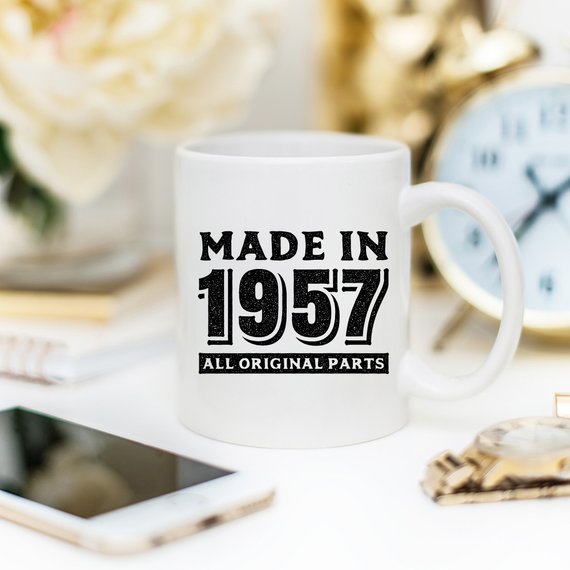 A humorous coffee mug featuring the text 'Made In 1957, All Original Parts - Funny Coffee Mug', showcasing a vibrant design perfect for 61st birthday celebrations.