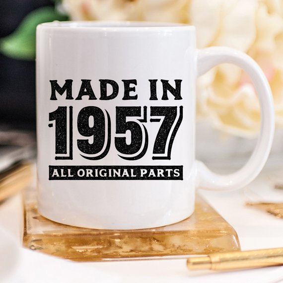 A humorous coffee mug featuring the text 'Made In 1957, All Original Parts - Funny Coffee Mug', showcasing a vibrant design perfect for 61st birthday celebrations.