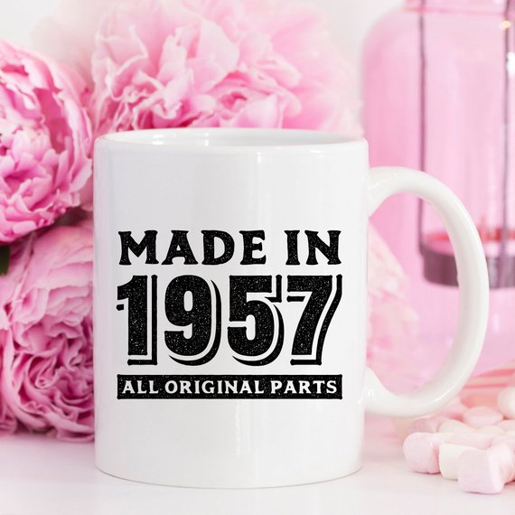 A humorous coffee mug featuring the text 'Made In 1957, All Original Parts - Funny Coffee Mug', showcasing a vibrant design perfect for 61st birthday celebrations.