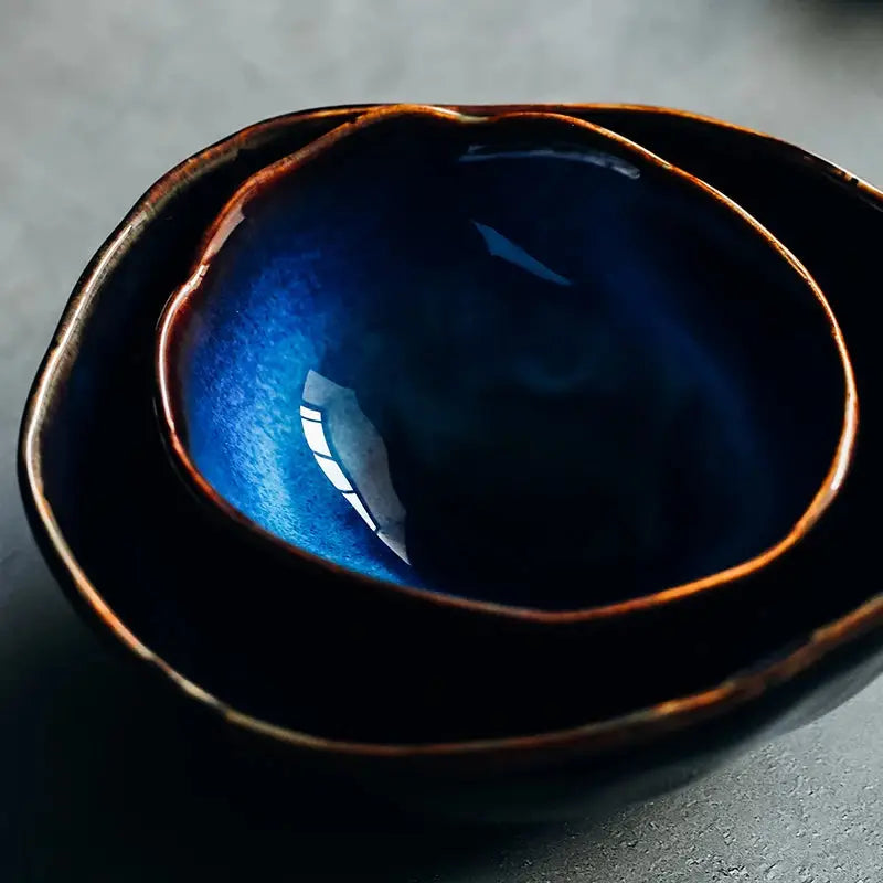 Maana Bowl featuring dark blue ceramic with golden stripes, elegantly designed for serving and decoration.