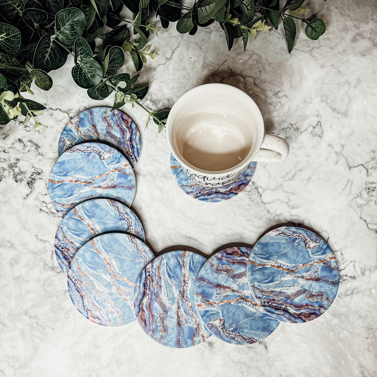 Set of four luxurious Marble Blue Coasters with a watercolor effect, featuring shades of blue and gold accents, displayed in a brown box.