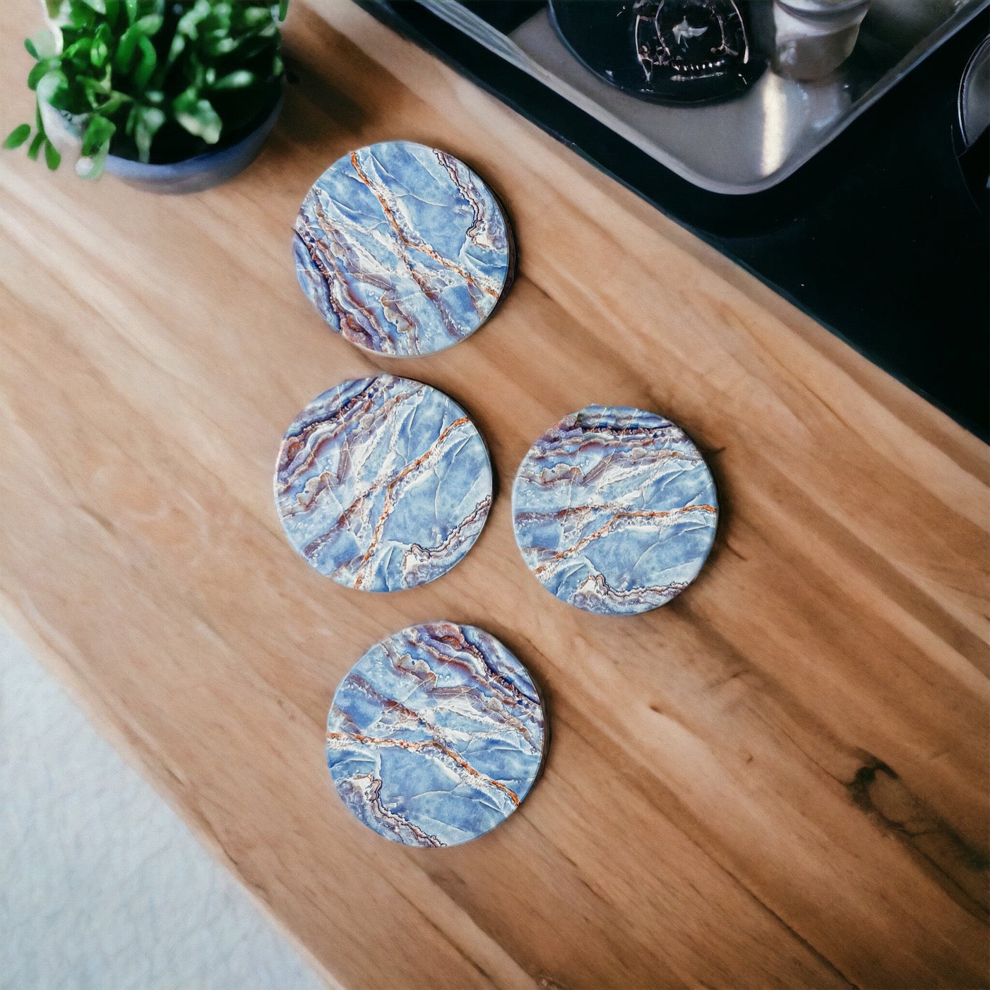 Set of four luxurious Marble Blue Coasters with a watercolor effect, featuring shades of blue and gold accents, displayed in a brown box.