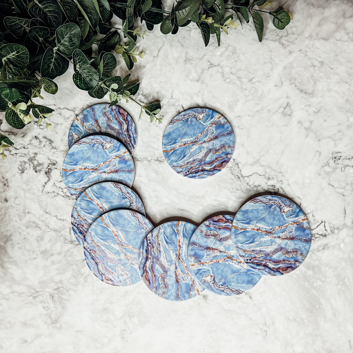 Set of four luxurious Marble Blue Coasters with a watercolor effect, featuring shades of blue and gold accents, displayed in a brown box.