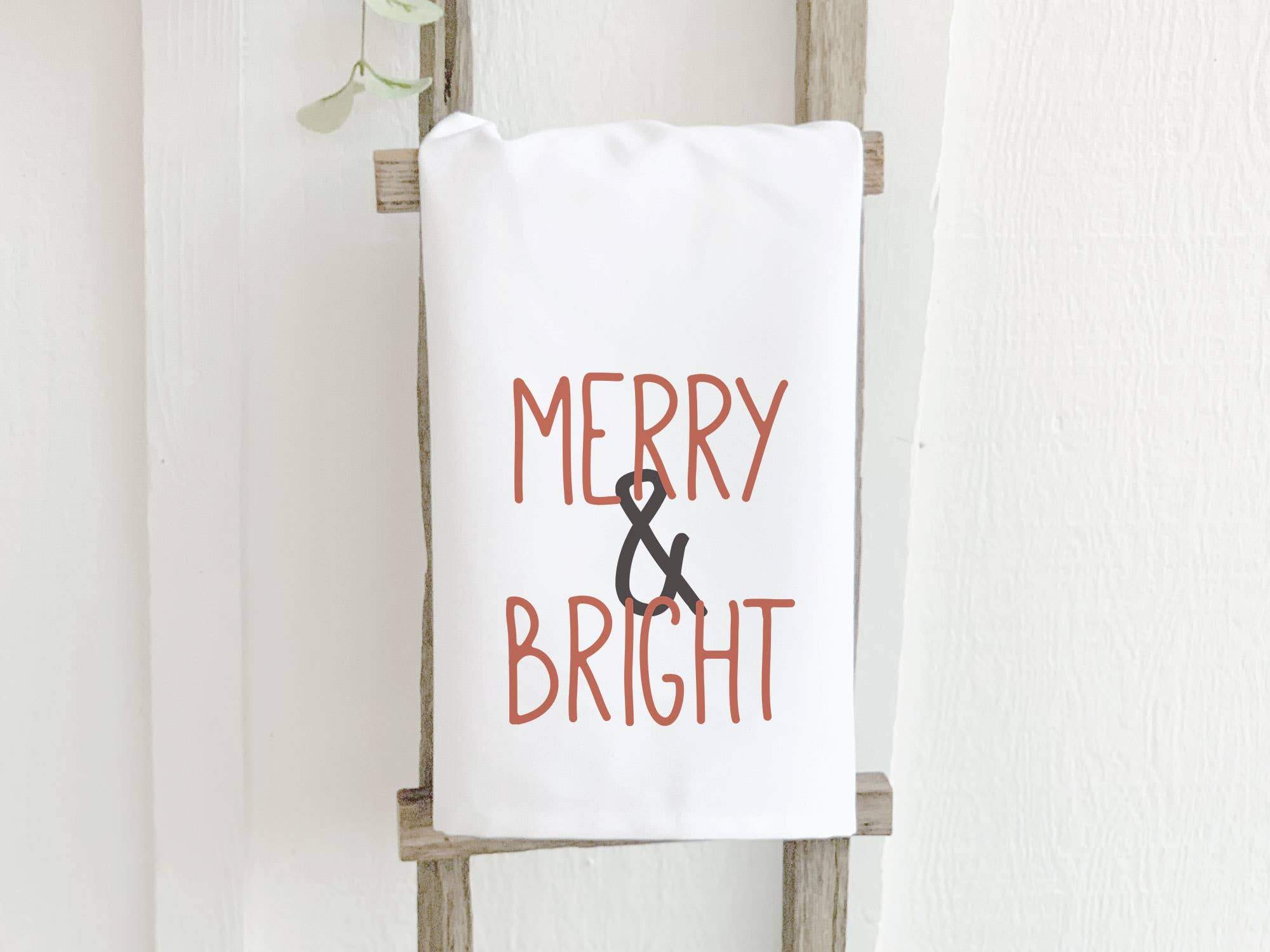 Merry & Bright Cotton Tea Towel featuring vibrant designs and hemmed edges, perfect for kitchen use.