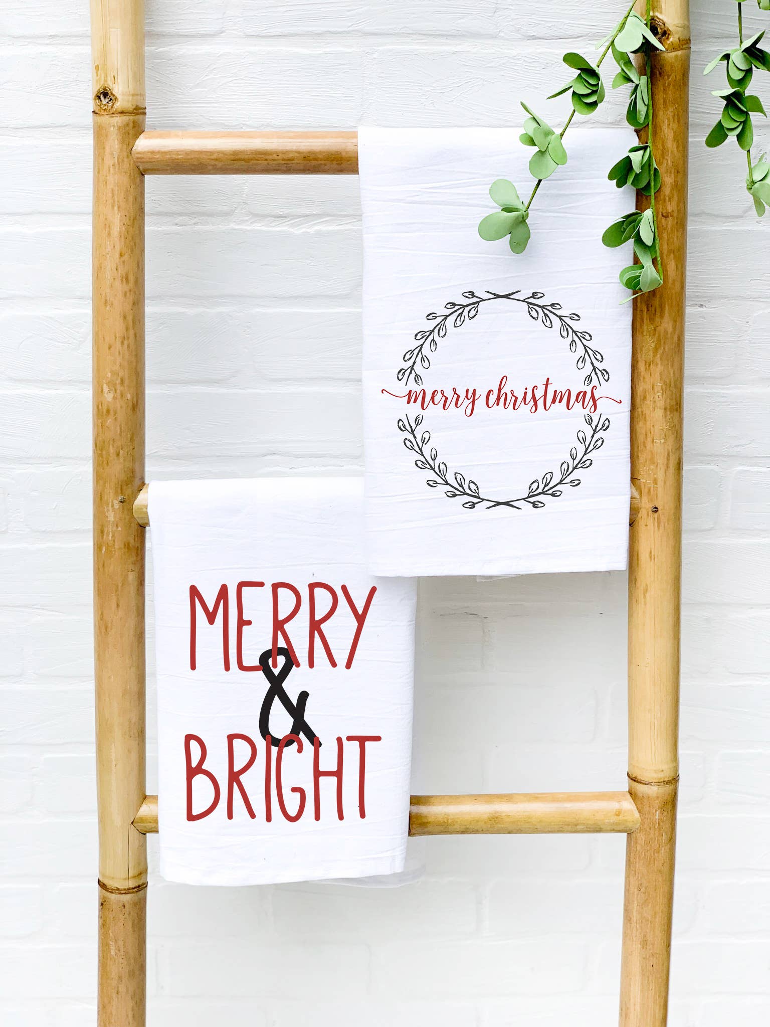 Merry & Bright Cotton Tea Towel featuring vibrant designs and hemmed edges, perfect for kitchen use.