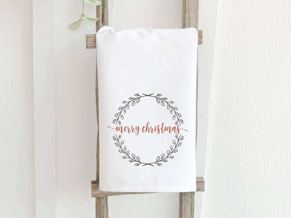 Merry Christmas Wreath cotton tea towel featuring a festive wreath design, made from 100% absorbent cotton, perfect for holiday kitchens.