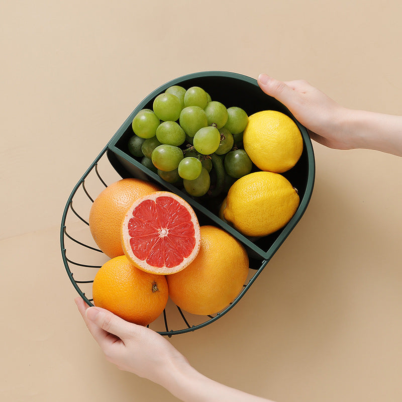 A stylish metal hollowed out fruit and vegetable snack tray bowl basket in dark green and gold, showcasing a variety of fresh fruits and snacks.