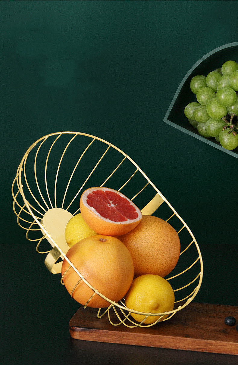 A stylish metal hollowed out fruit and vegetable snack tray bowl basket in dark green and gold, showcasing a variety of fresh fruits and snacks.