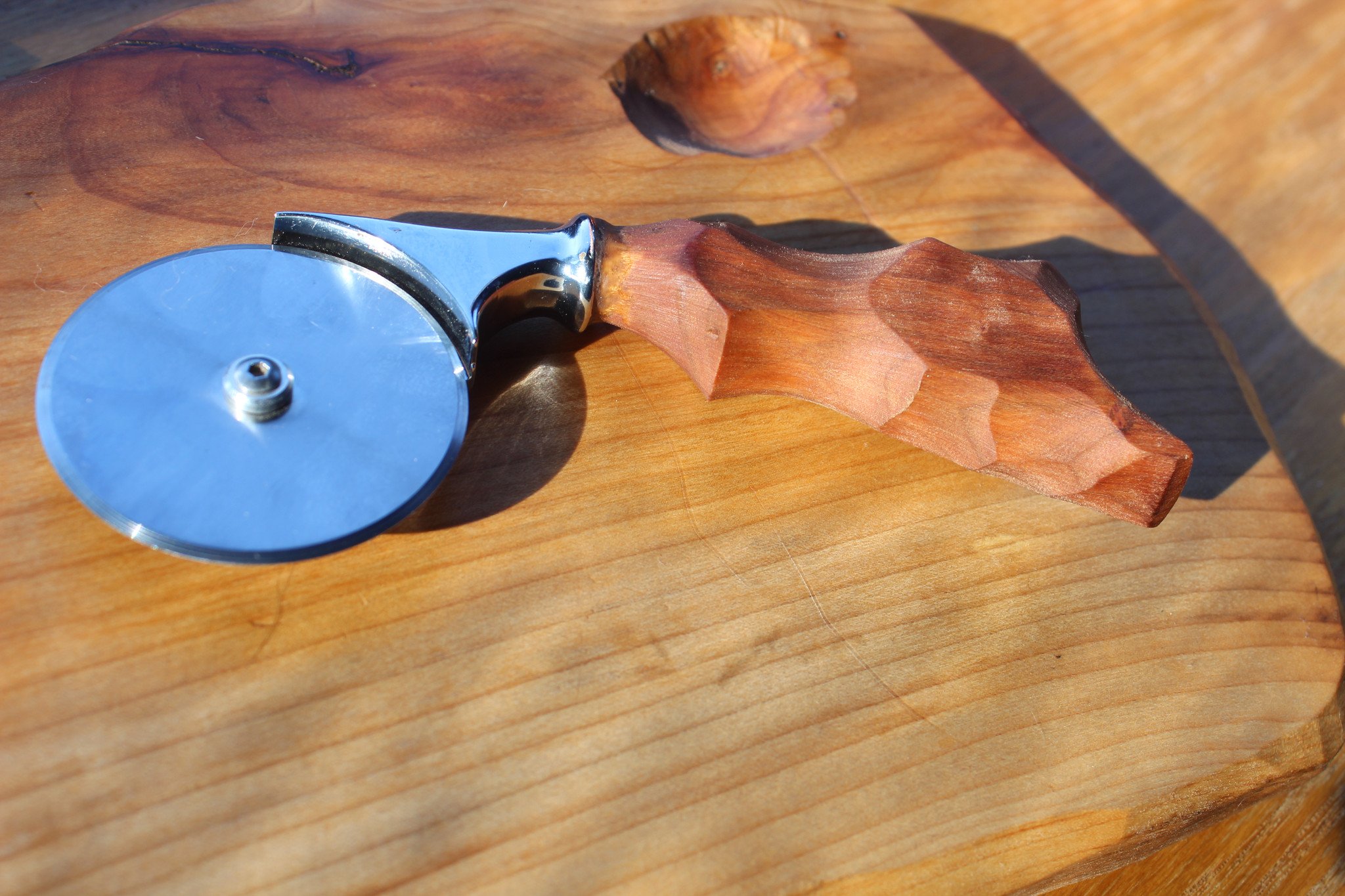 A stylish Mini Pizza Cutter with an ergonomic wooden handle, available in Oak, Cherry, and Walnut finishes.