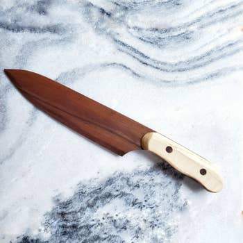 Model A Chef Knife made from urban waste lumber, showcasing its sharp blade and ergonomic handle.