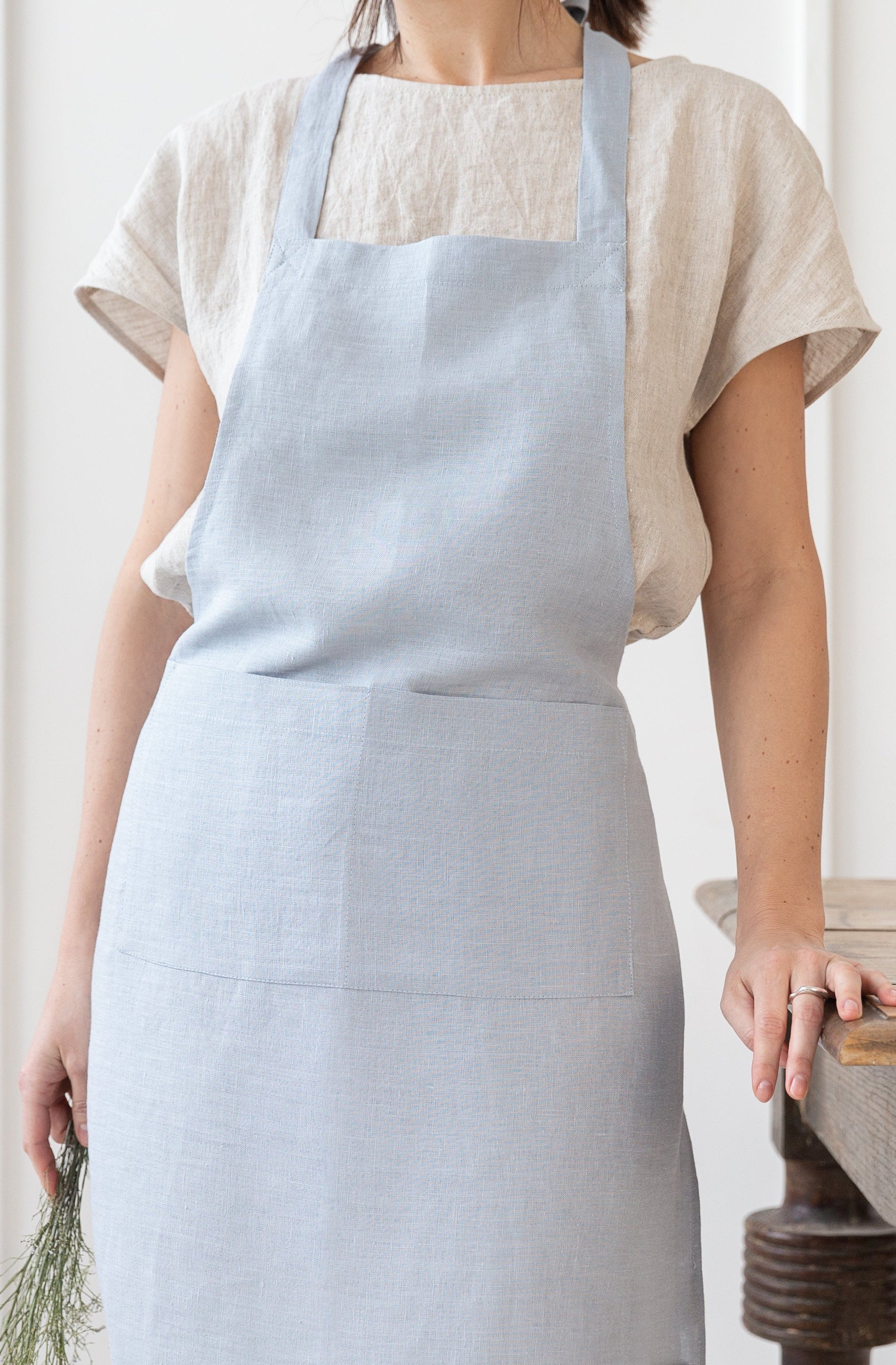 Moss Green linen apron with adjustable back ties and front pockets, showcasing its elegant design and functionality.