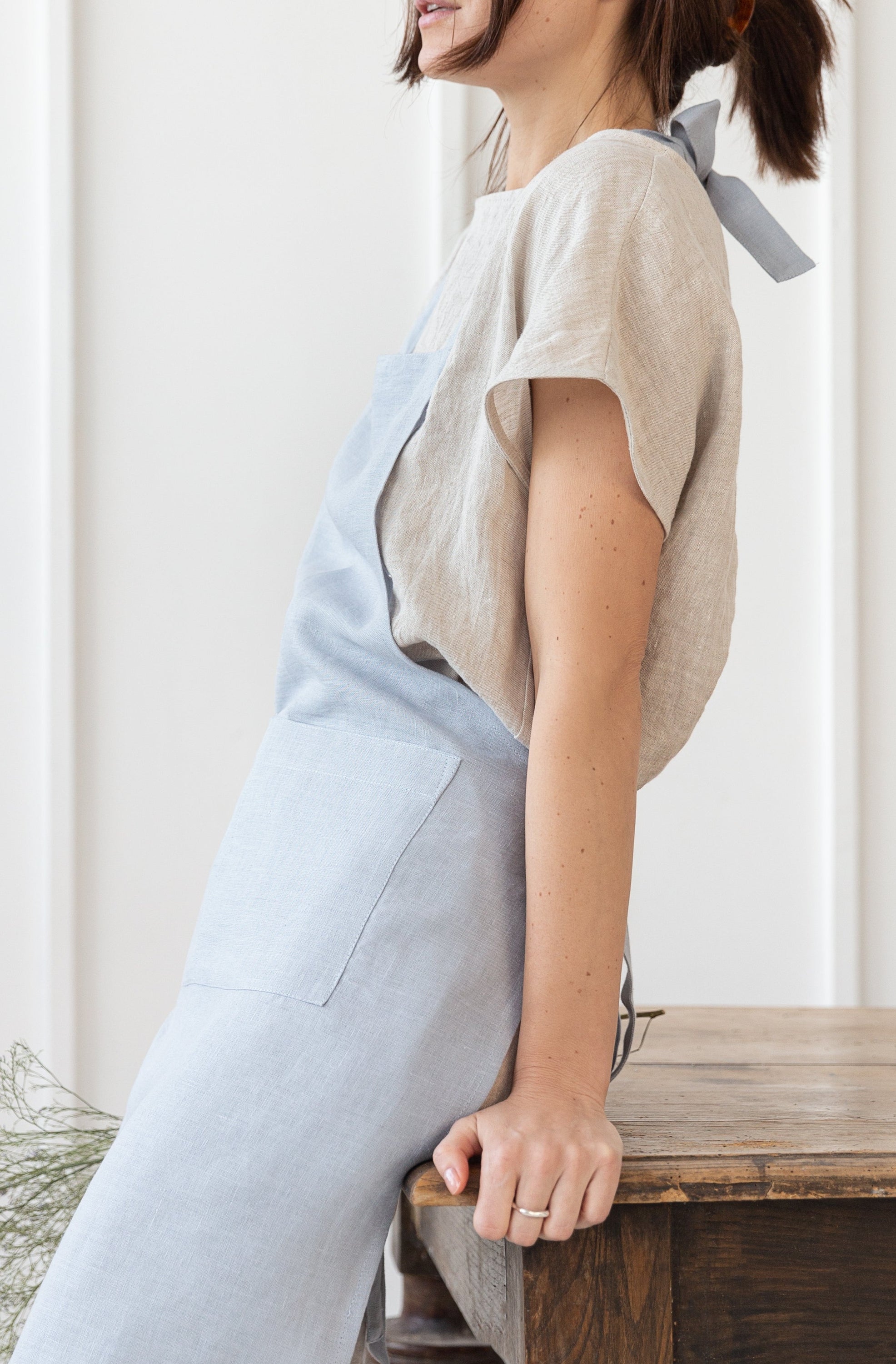 Moss Green linen apron with adjustable back ties and front pockets, showcasing its elegant design and functionality.