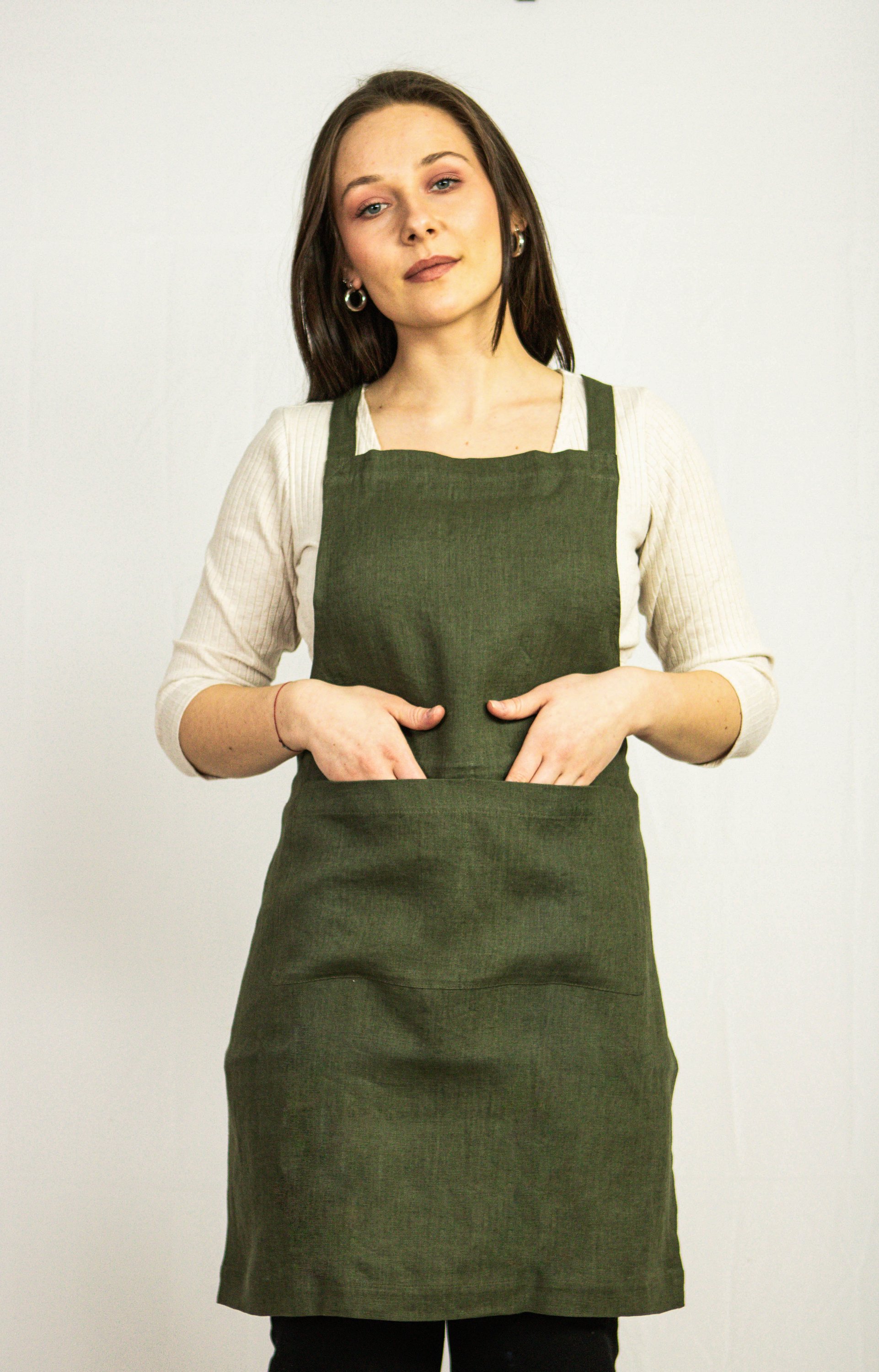 Moss Green linen apron with adjustable back ties and front pockets, showcasing its elegant design and functionality.