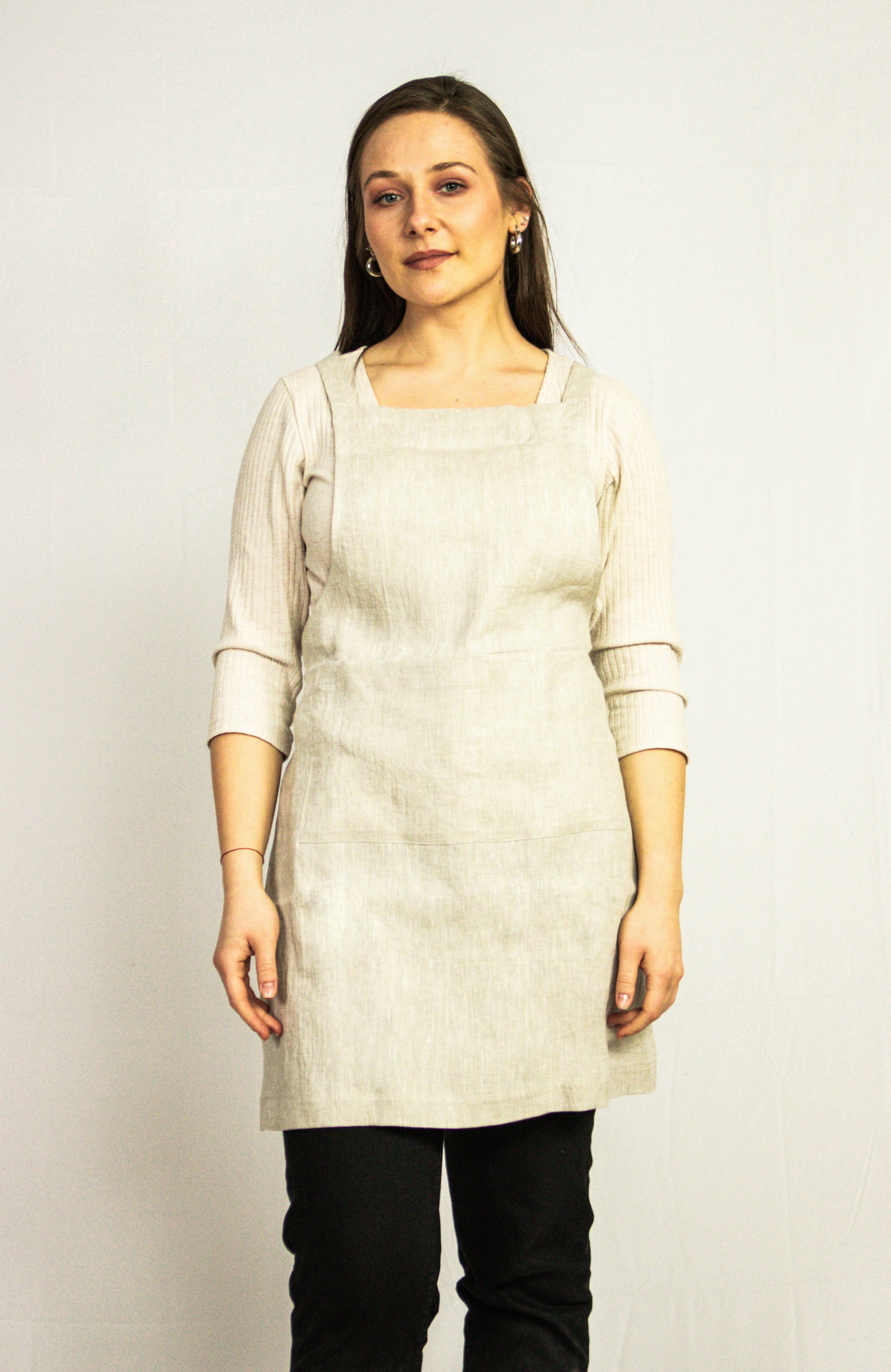 Moss Green linen apron with adjustable back ties and front pockets, showcasing its elegant design and functionality.